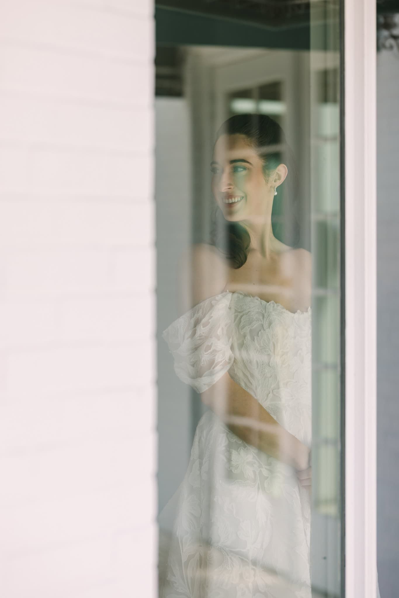 bride inside, looking in through the window with reflection