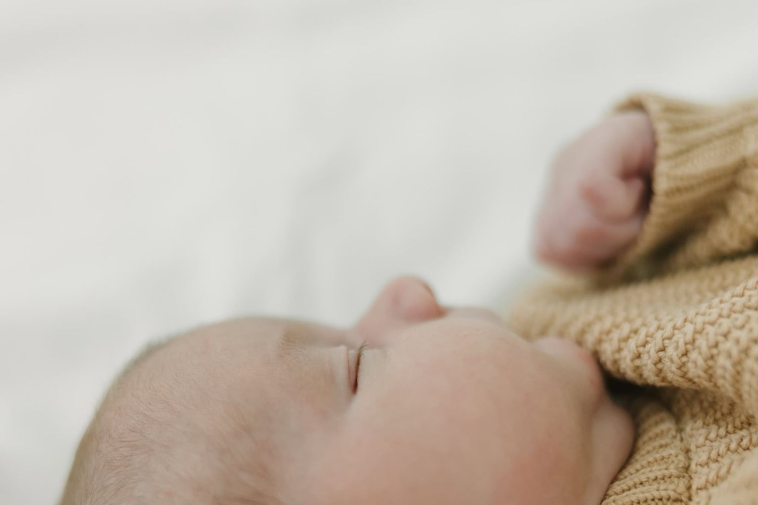 close up detail of newborn baby face showing his little nose and eyelashes