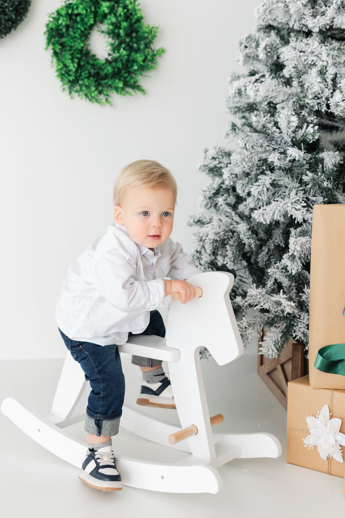 little boy on rocking horse in front of Christmas tree