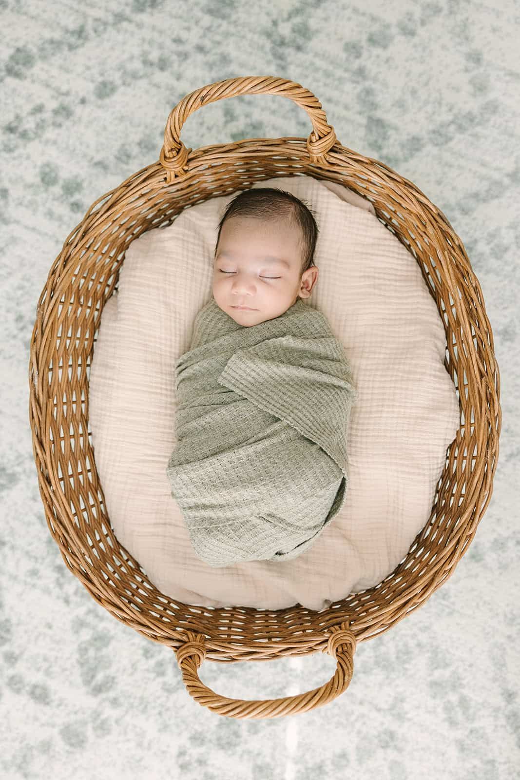 newborn baby swaddled up and laying in a basket