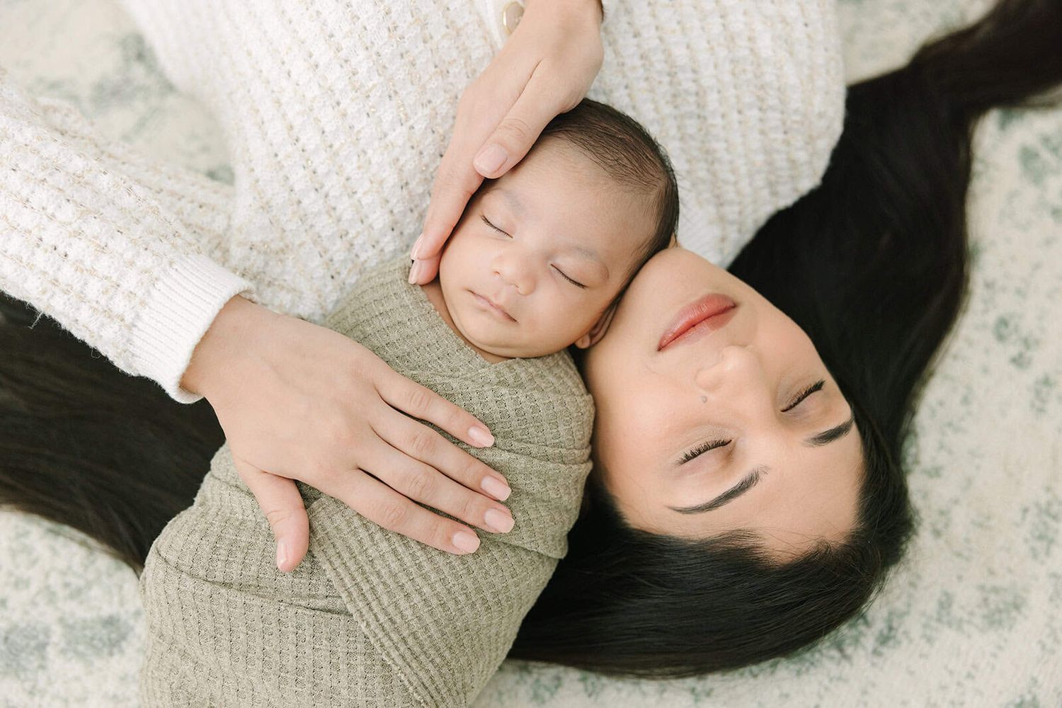 newborn baby swaddled and snuggled up on mom from above