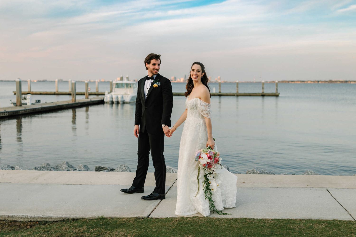 groom looking at bride as he walks her down the sidewalk, bride smiling at camera