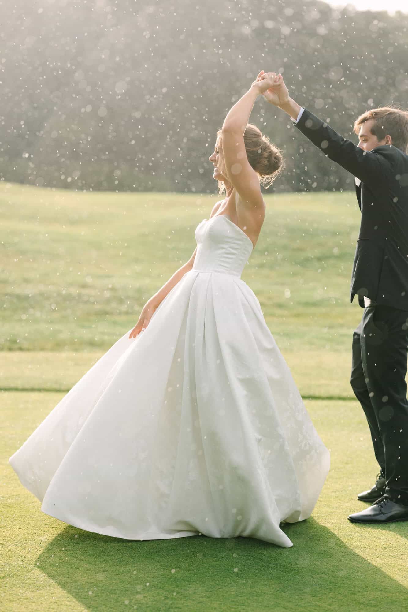 bride and groom dancing in the rain and her dress twirling
