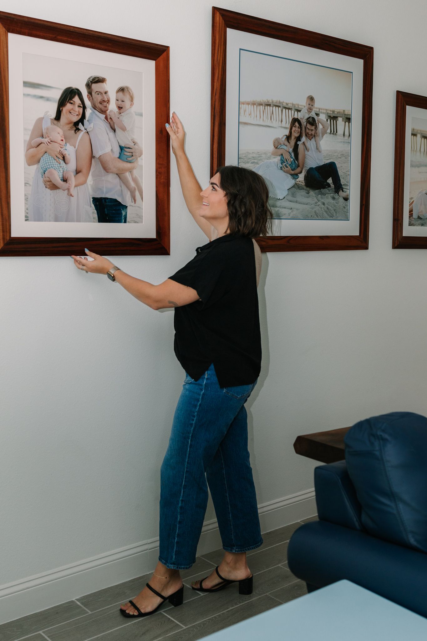 Caitlin hanging her own family portraits