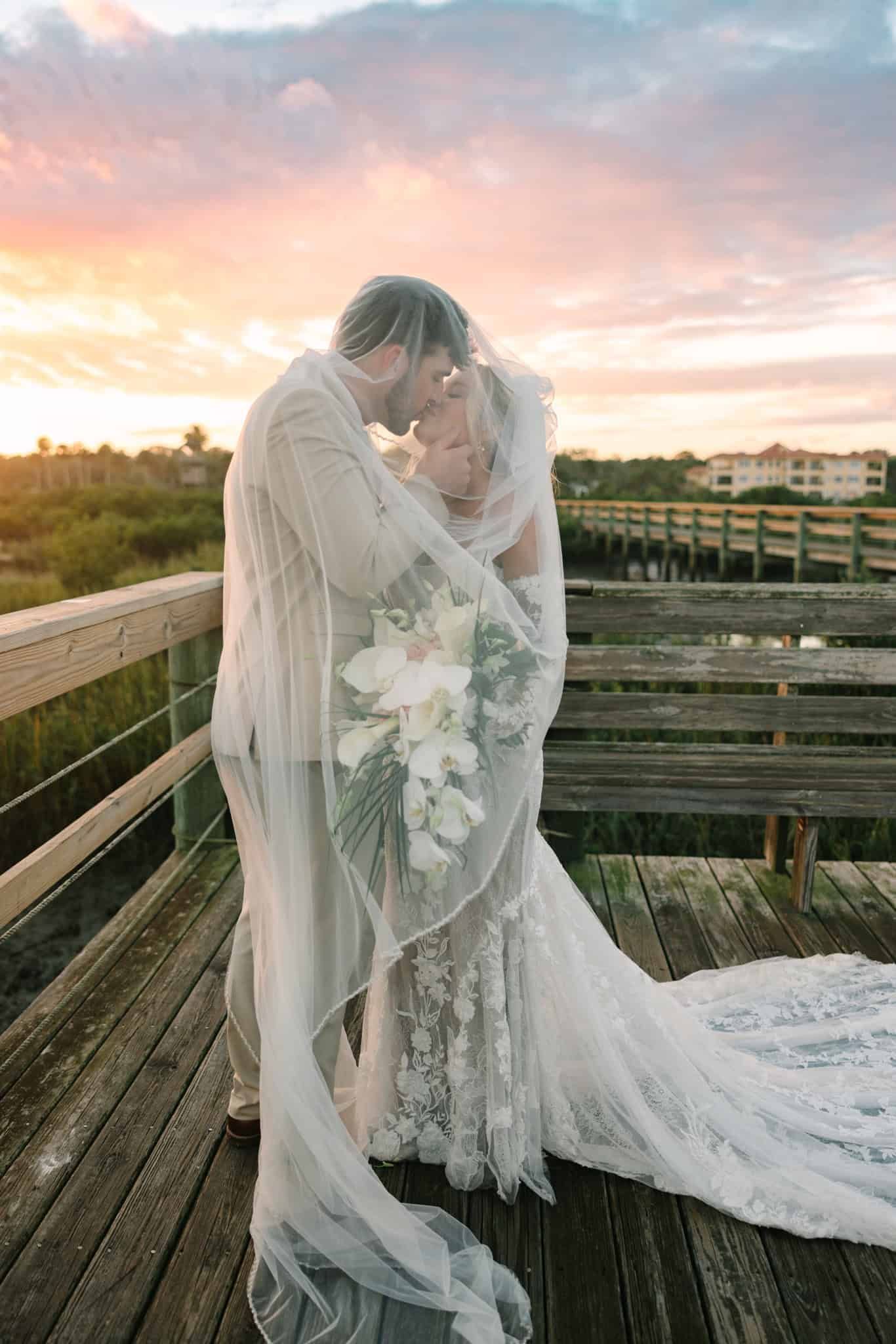 bride and groom giving a kiss under her veil