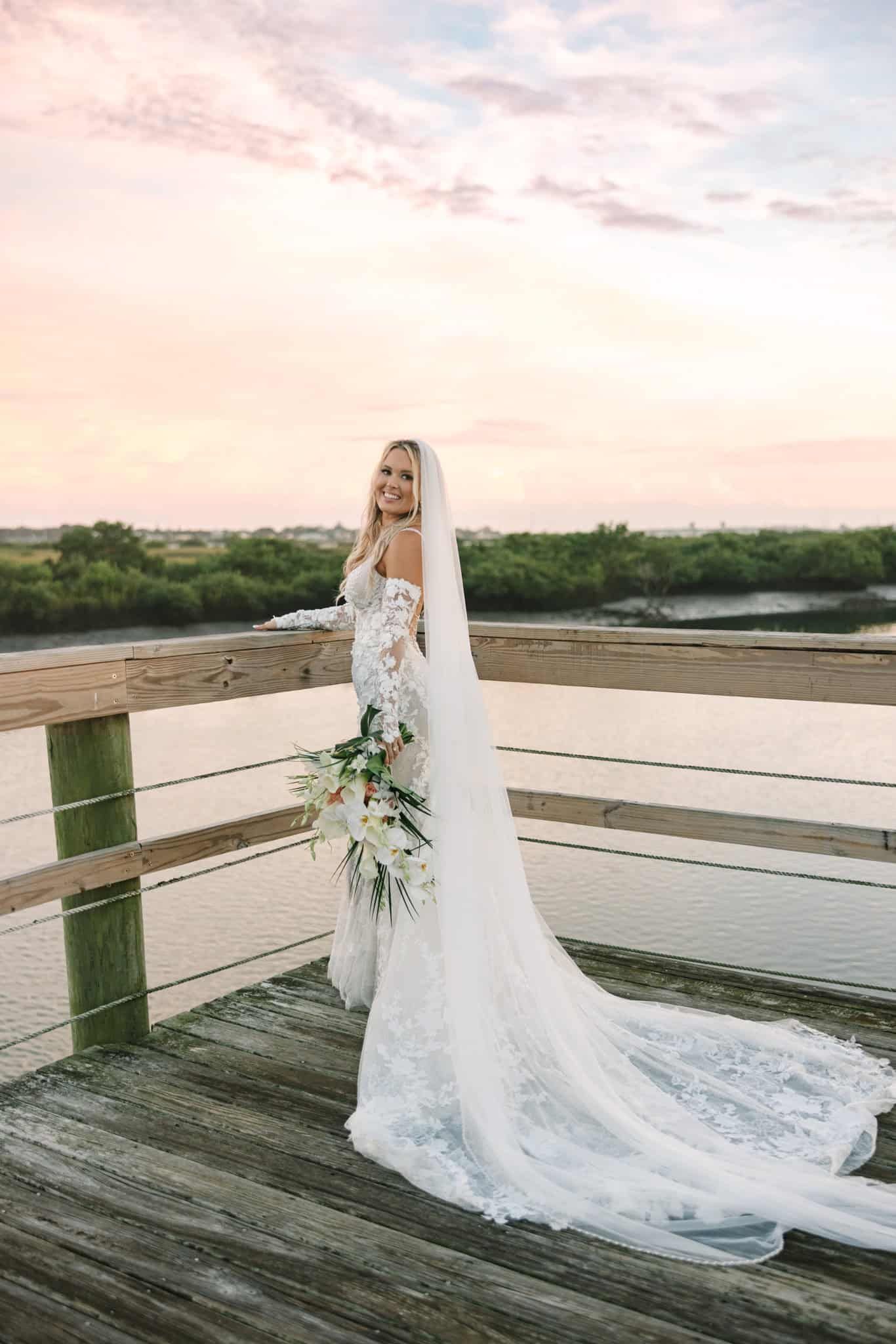 bride turned around holding her bouquet and showing her pretty veil and dress