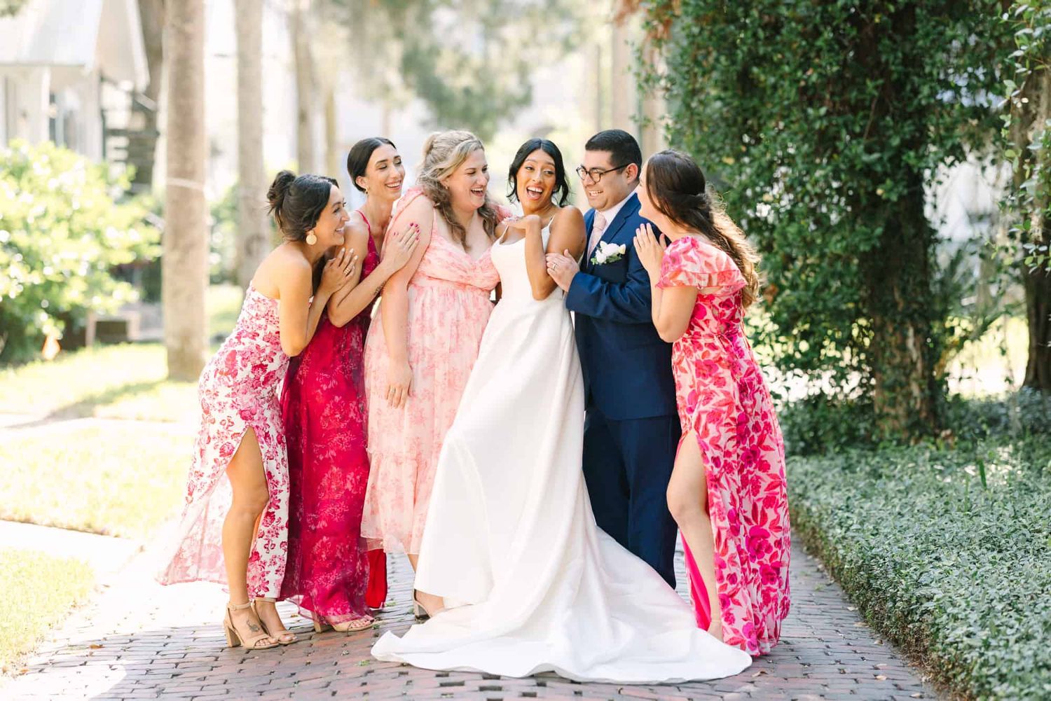 bride laughing with her bridesmaids and bridesman