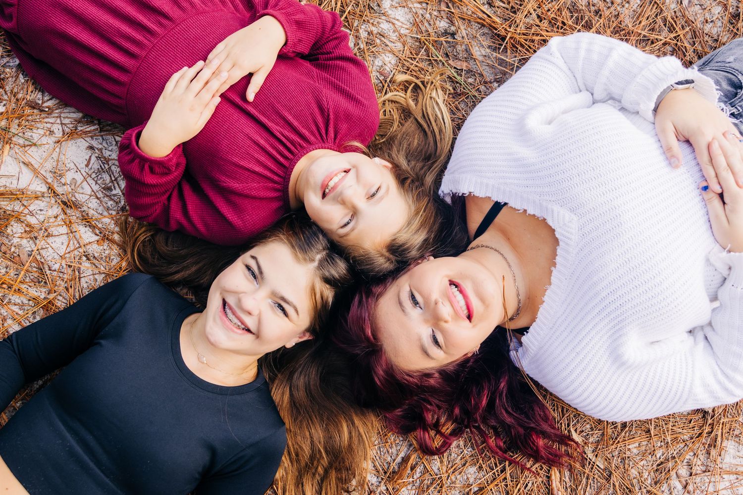jacksonville fl photographer three sisters laying on the ground smiling