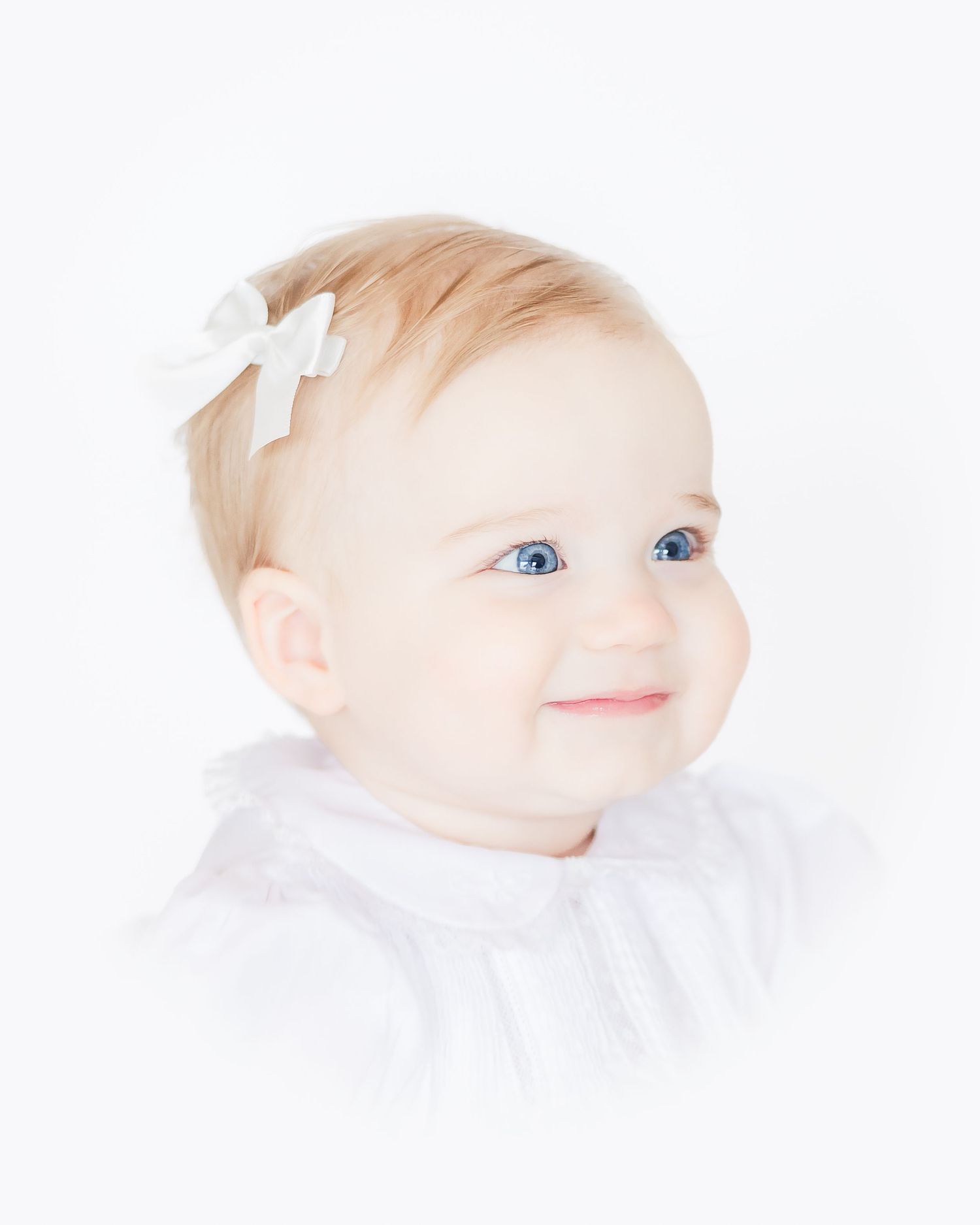heirloom portrait in color of baby girl looking off to the right smiling