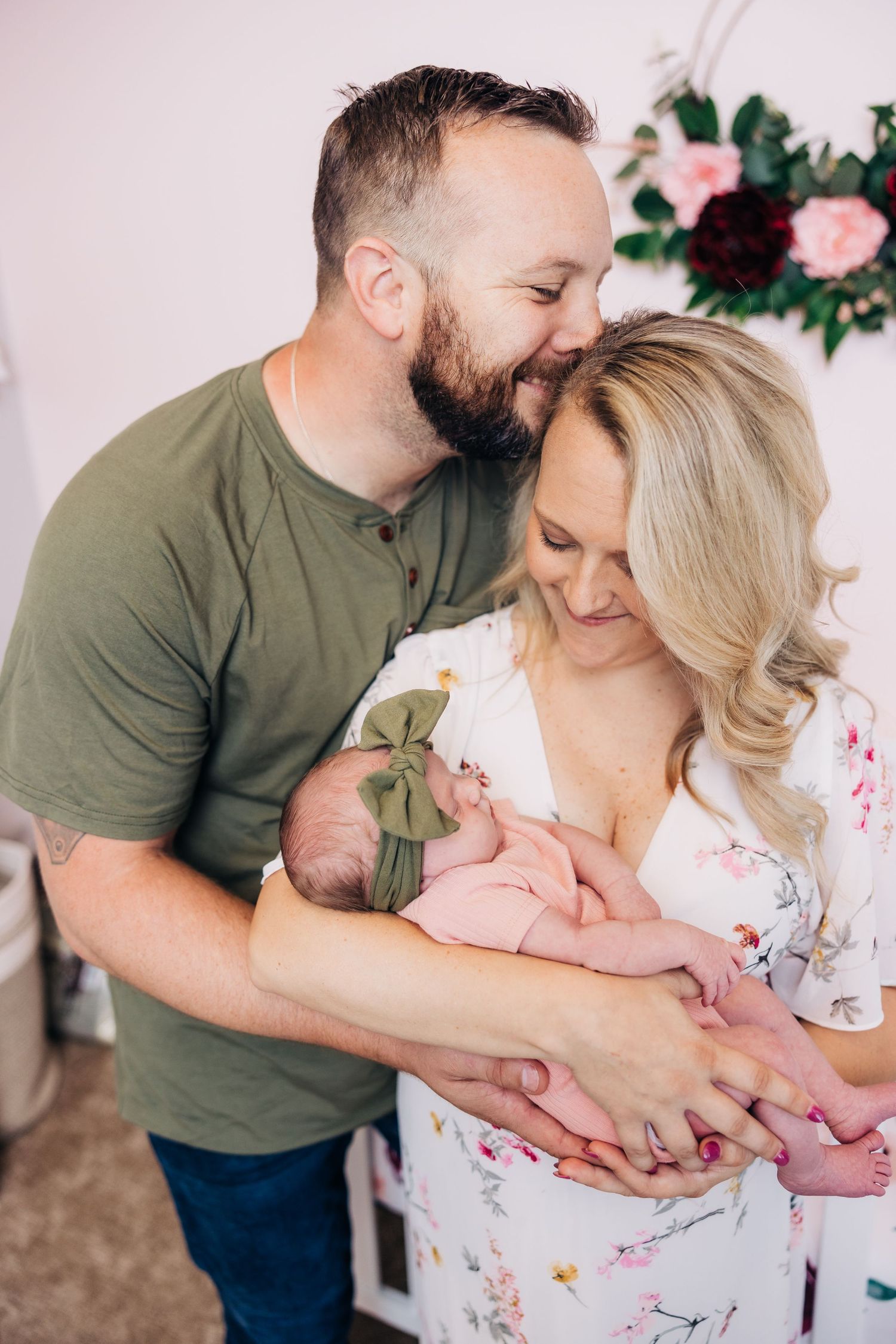 mom and dad smiling and adoring newborn baby