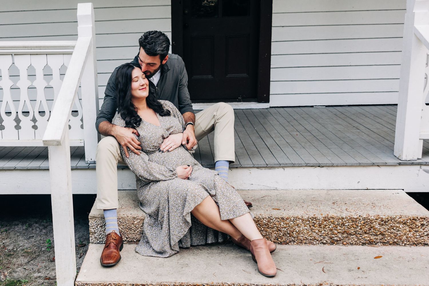 happy maternity couple sitting on the stairs