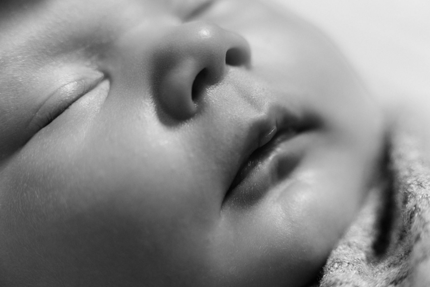 Close-up black and white portrait of a peaceful sleeping newborn baby's face by Saint Augustine fl newborn photographer