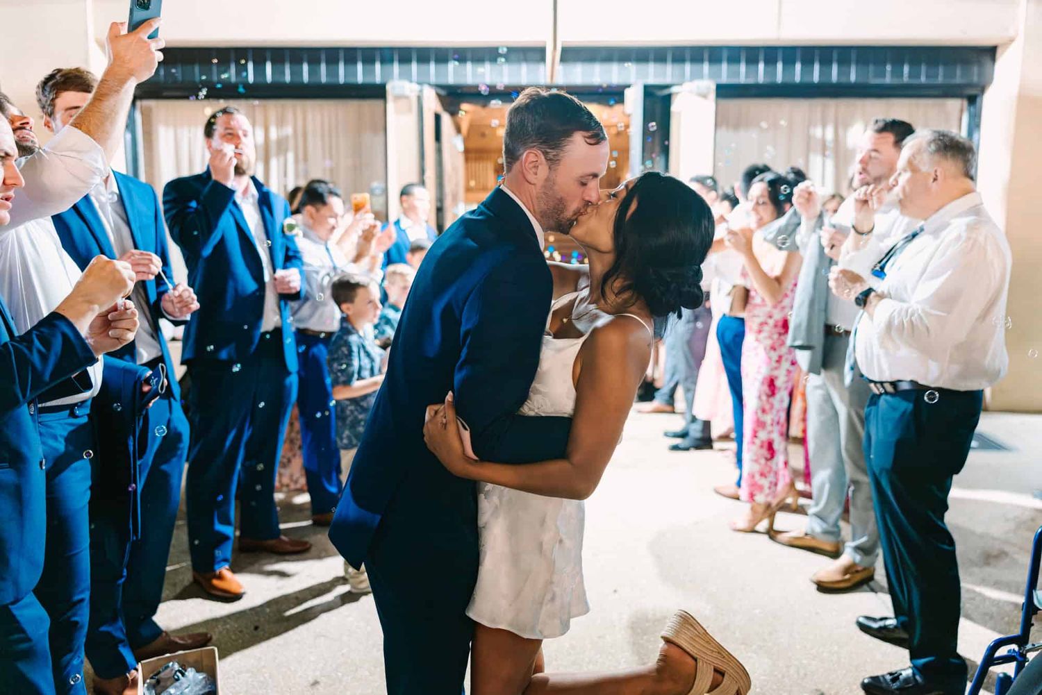 bride and groom kissing during bubble grand exit