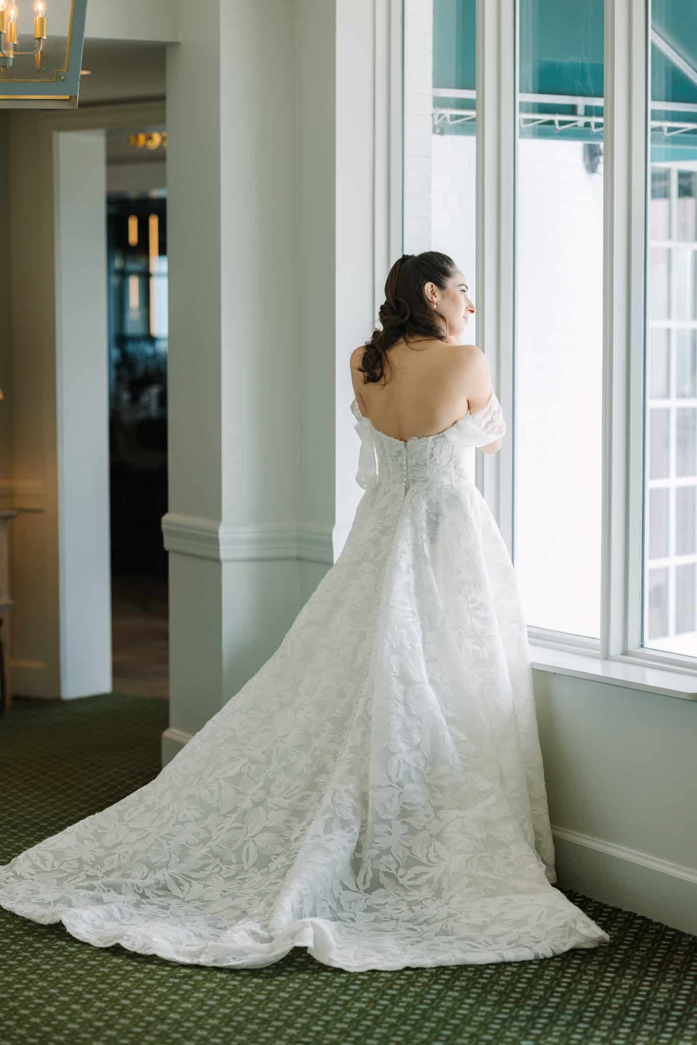 bride looking out the window in her wedding dress