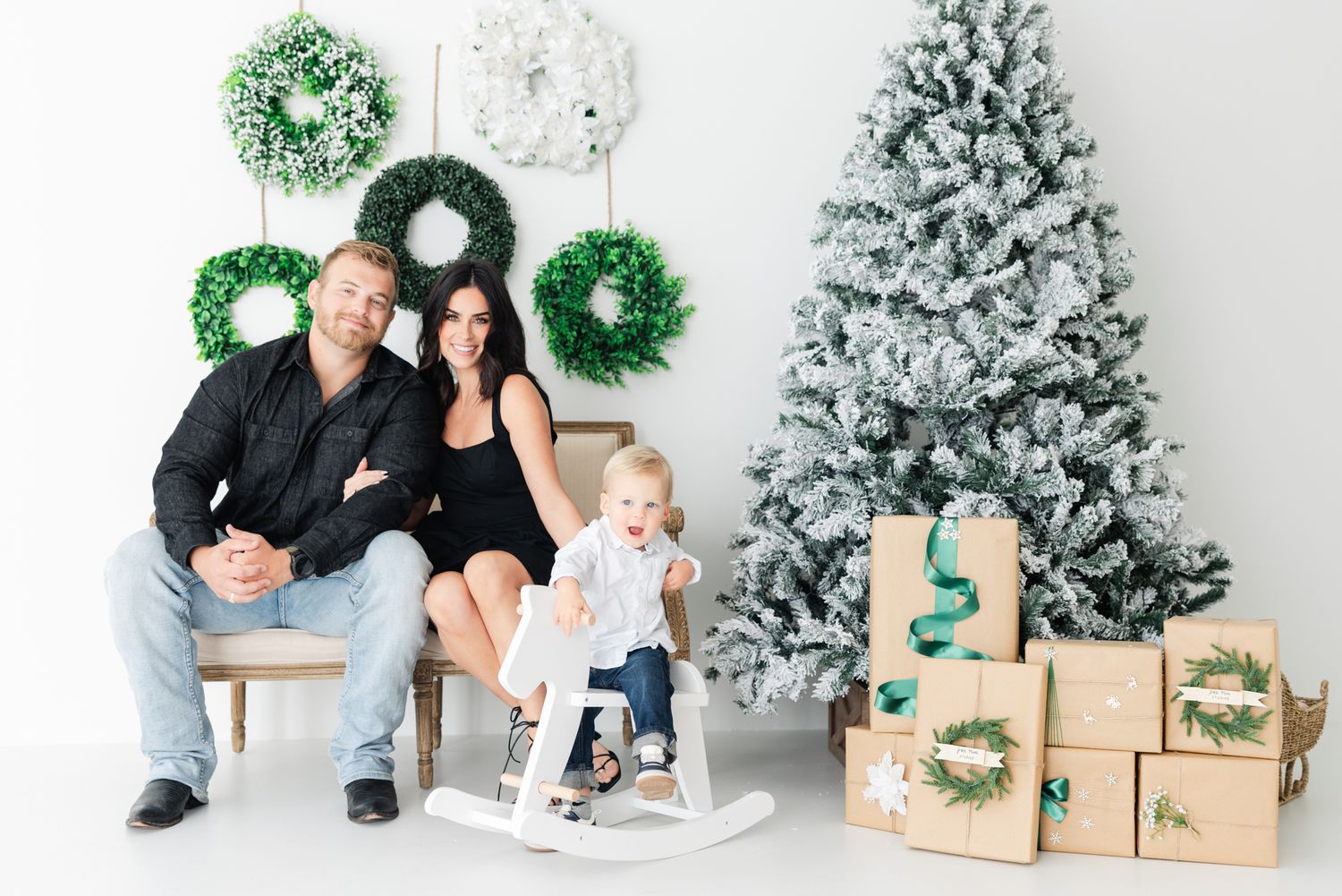 family in Christmas studio setup with son on rocking horse