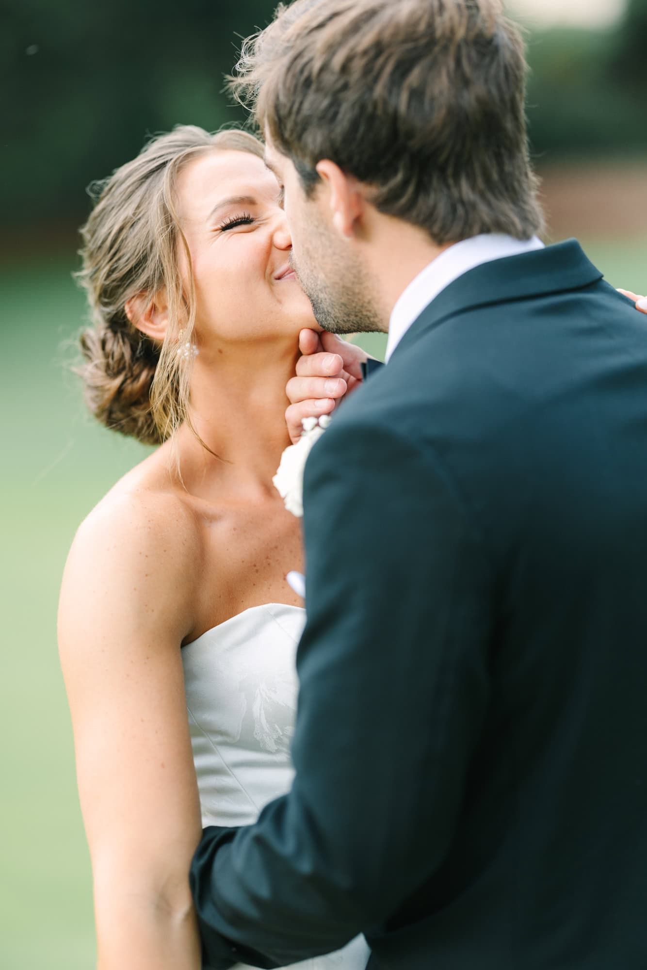 groom holding brides chin to give her a kiss