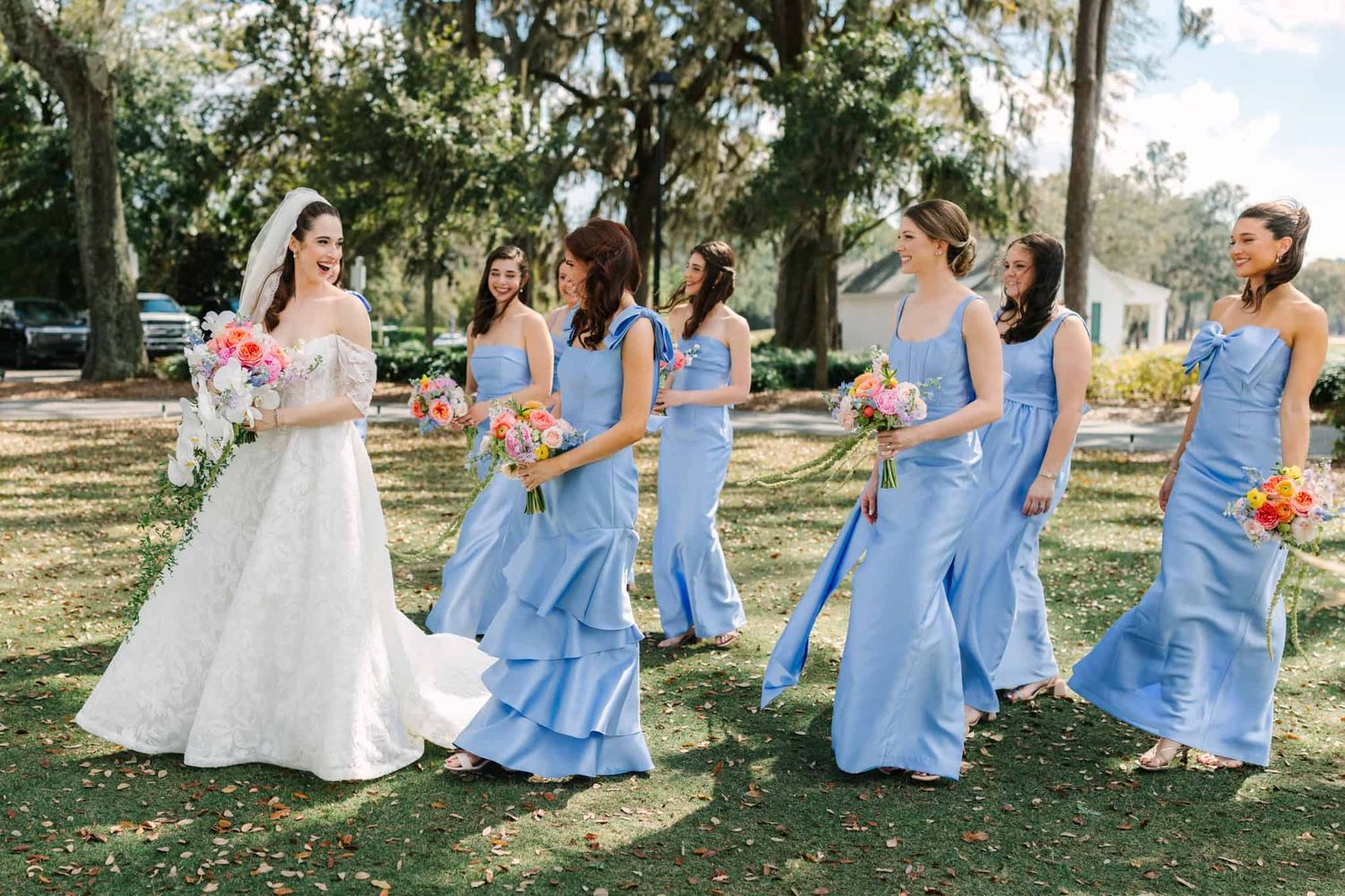 bride walking looking back at her bridesmaids and laughing
