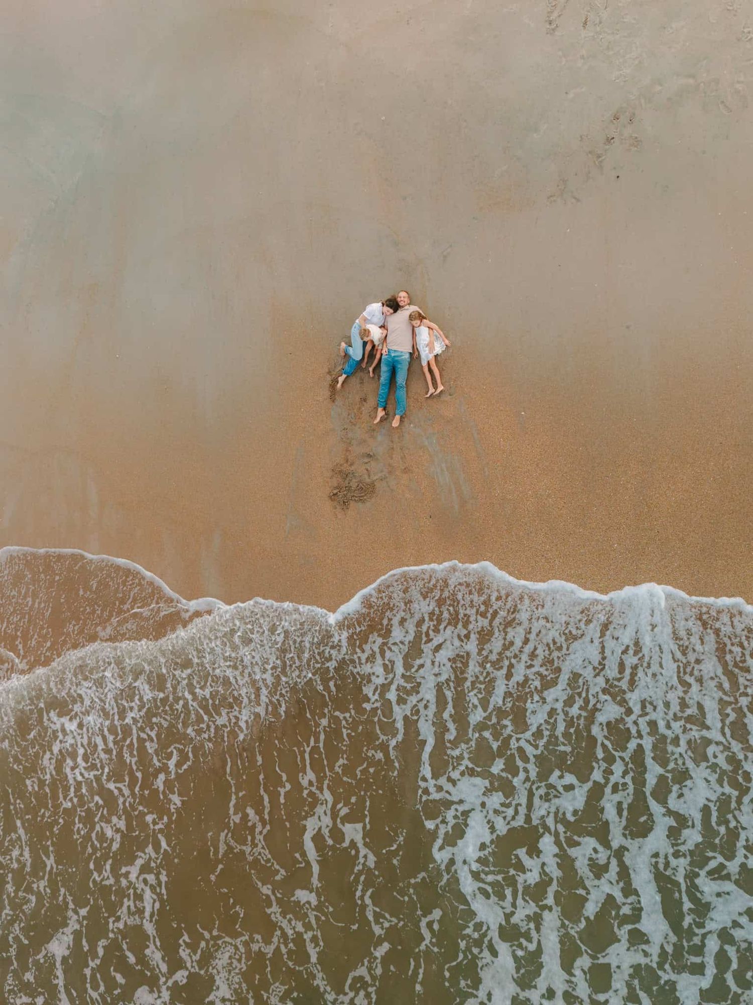 drone image of family laying on the beach