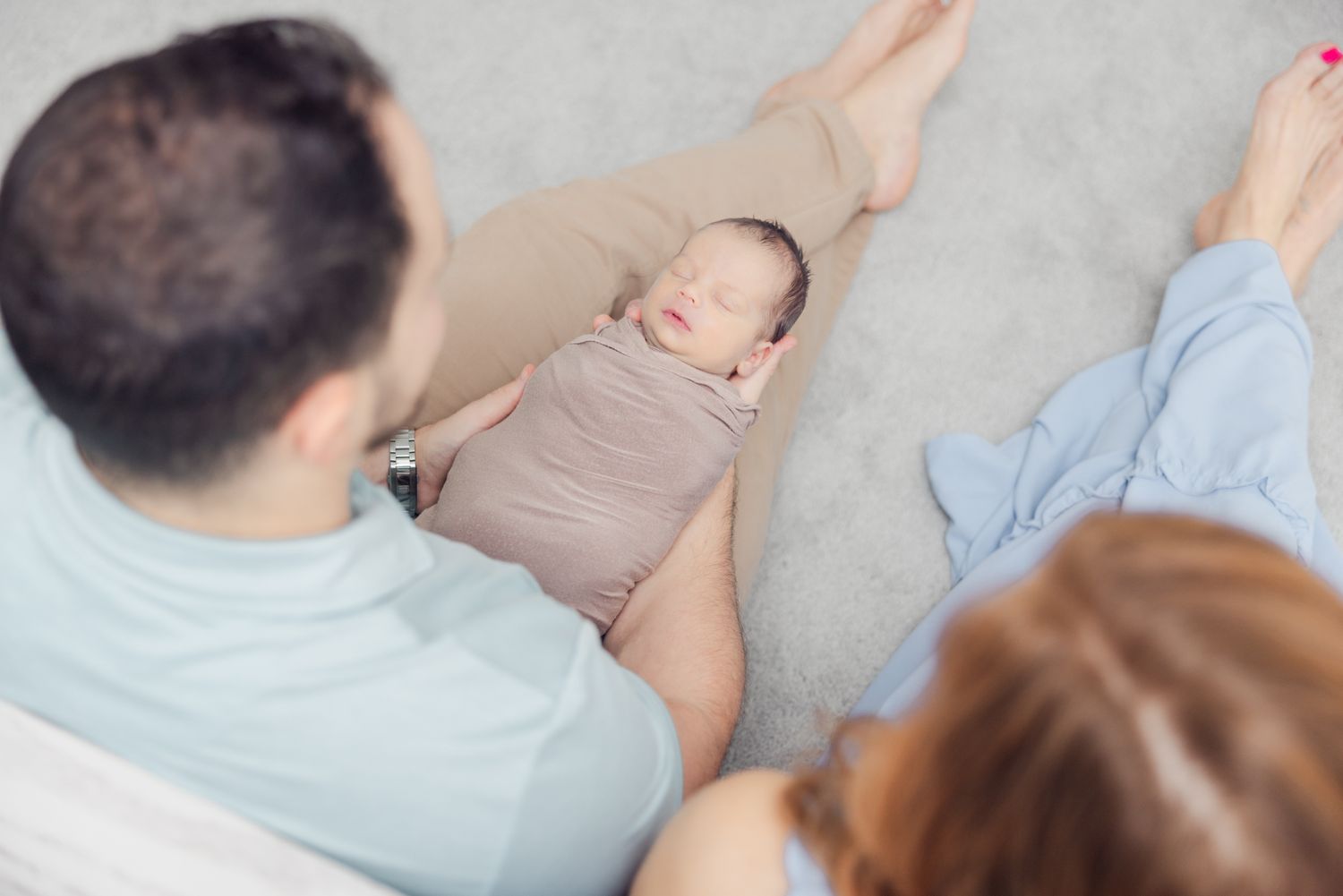 image looking down from above of dad holding newborn baby