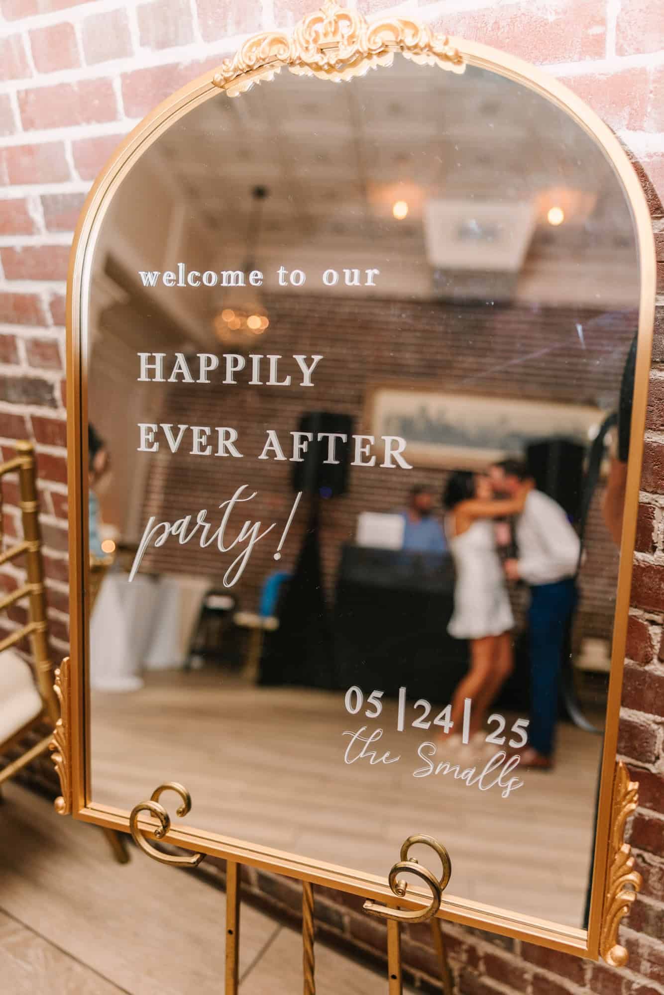 welcome sign on a mirror with bride and groom reflection of them kissing