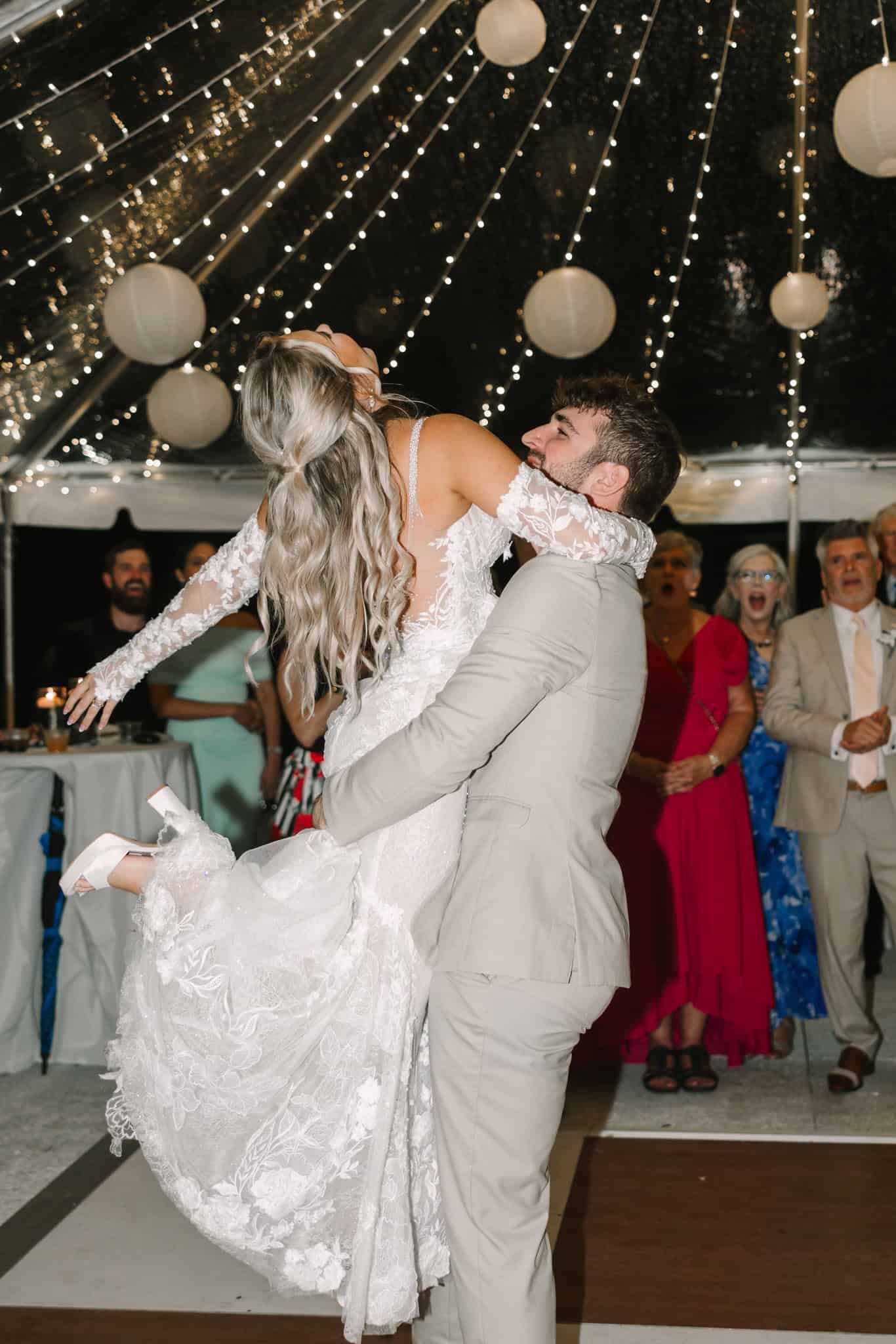 groom holding bride to twirl her as she arches back