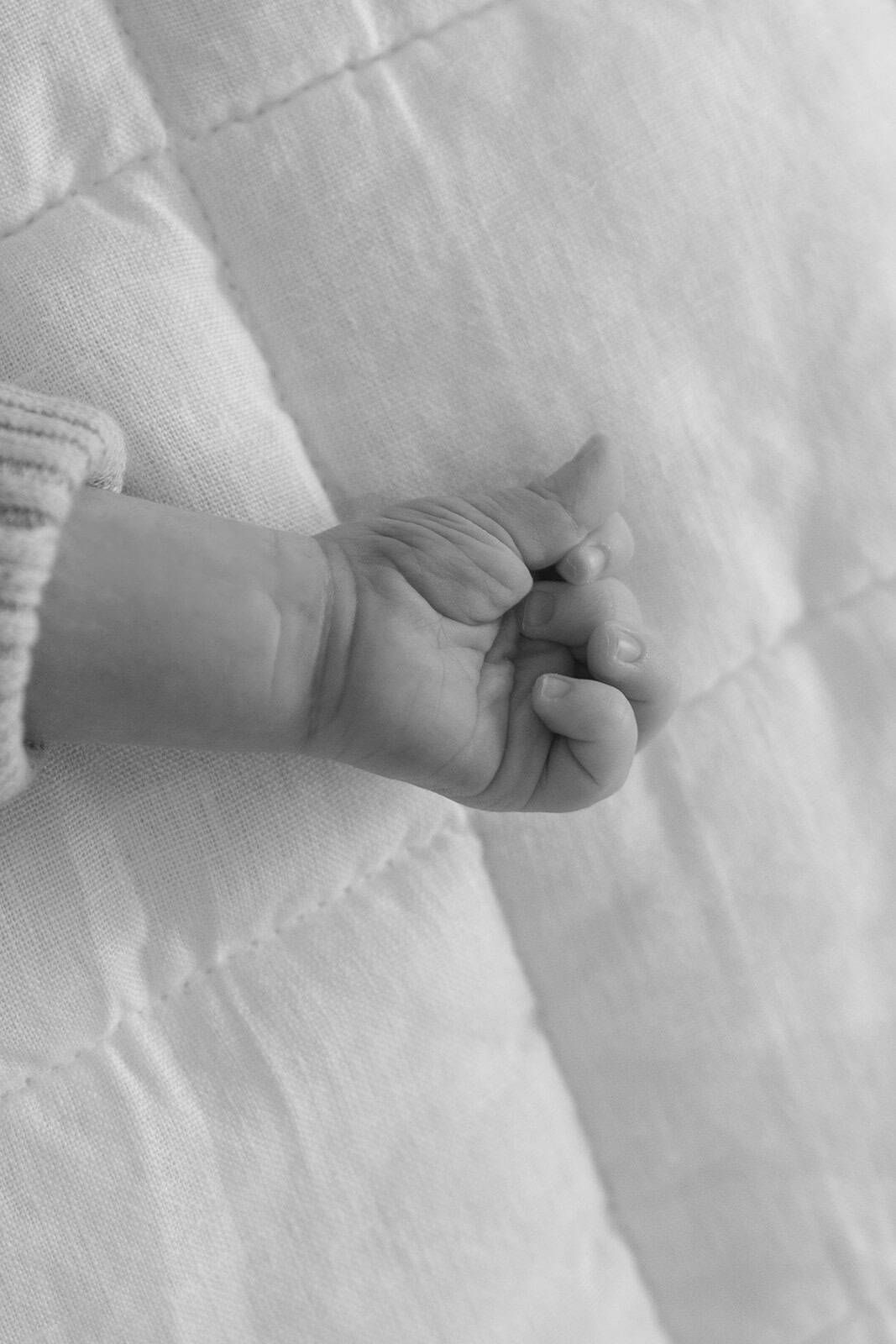 black and white photo of newborn baby hand