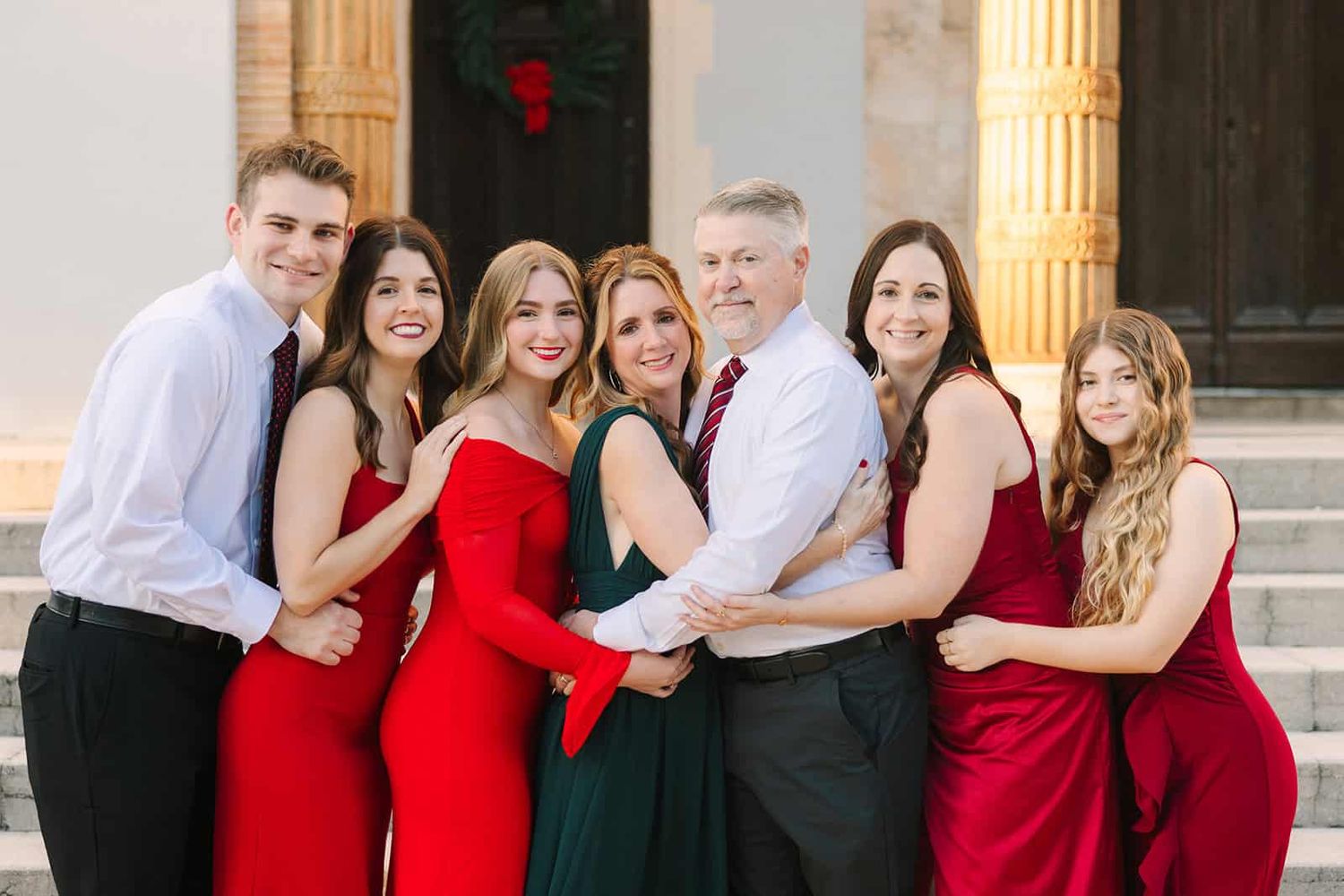 extended family at Christmas time in red and green formal wear