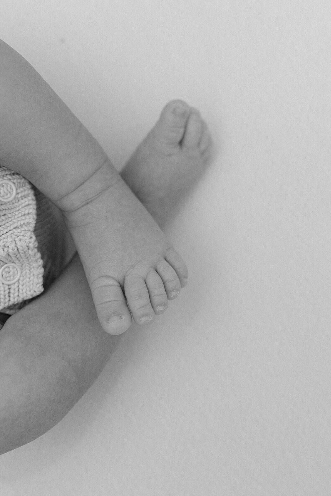 baby feet crossing in black and white taken by Jacksonville fl photographer