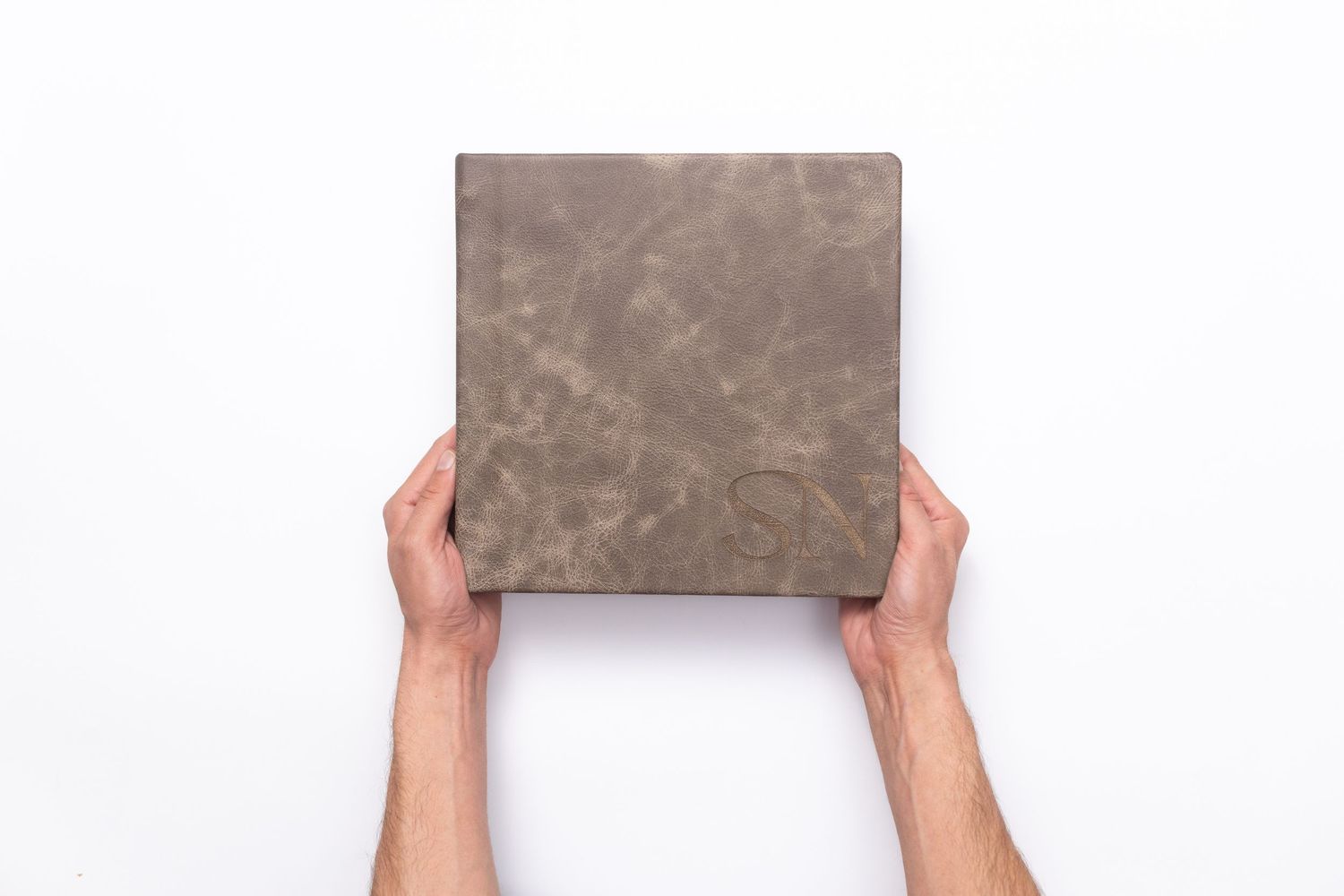 hands holding up a leather album showing size