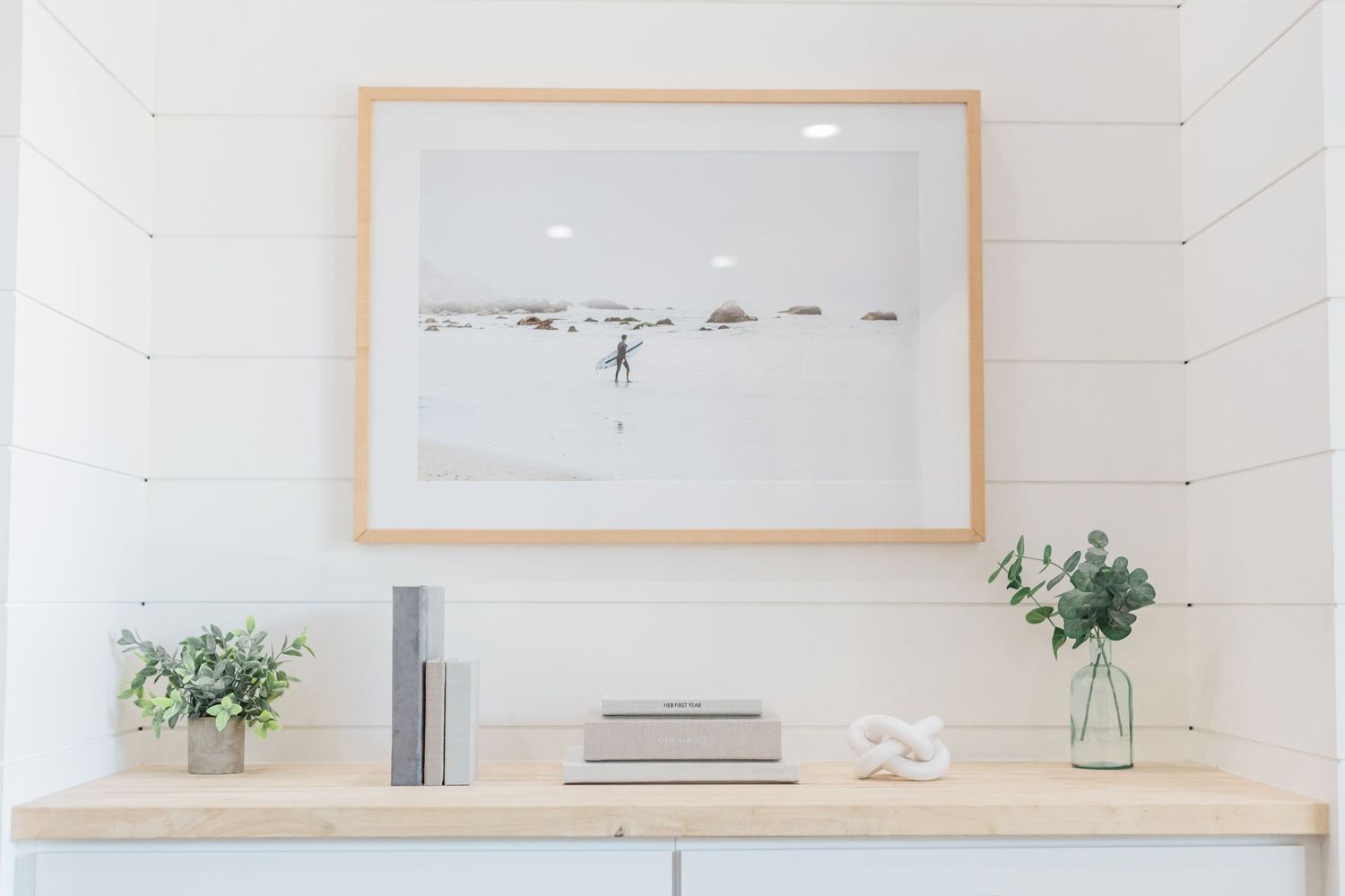 framed photo on the wall over a table with albums