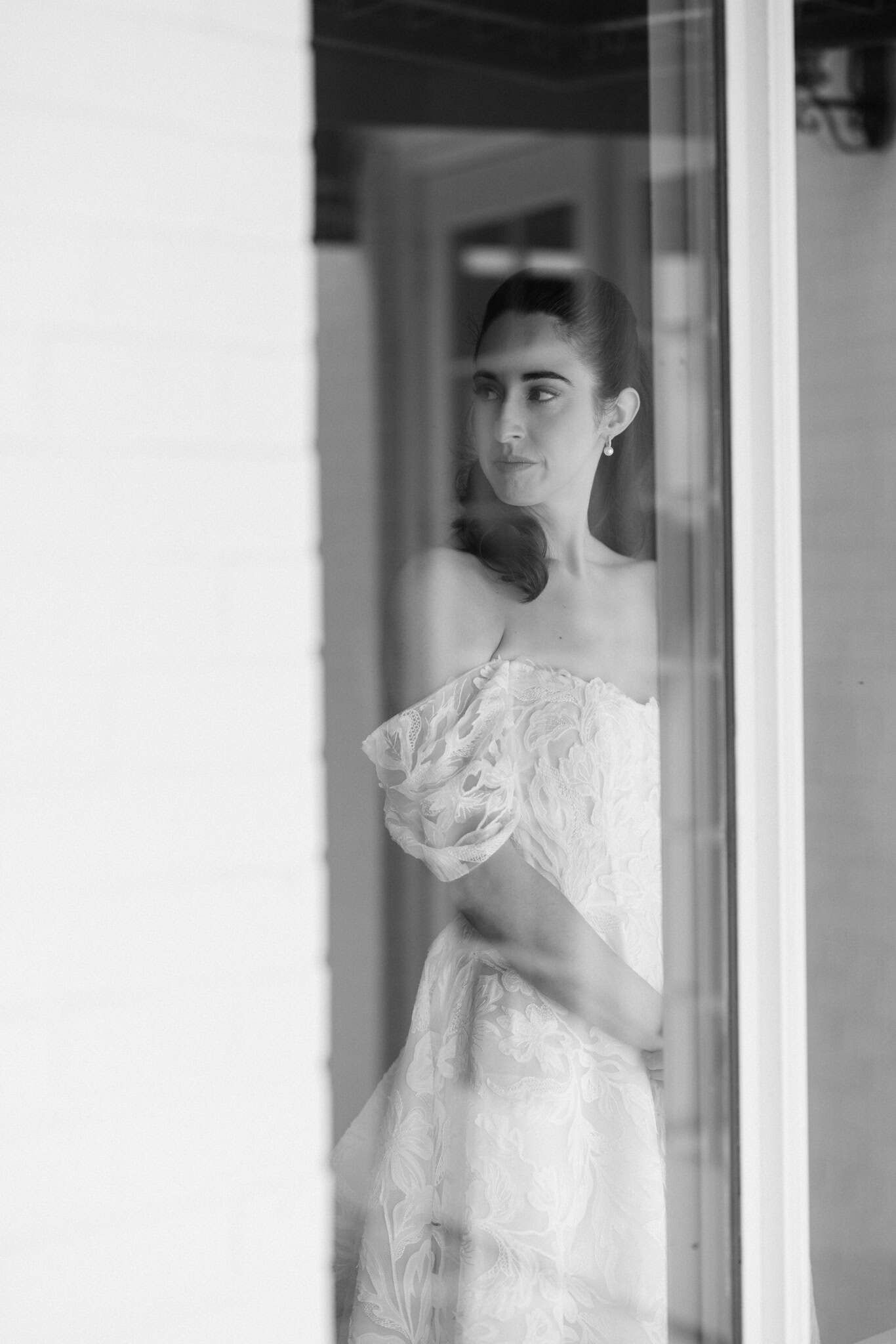 bride in black and white looking inside from outside with a reflection