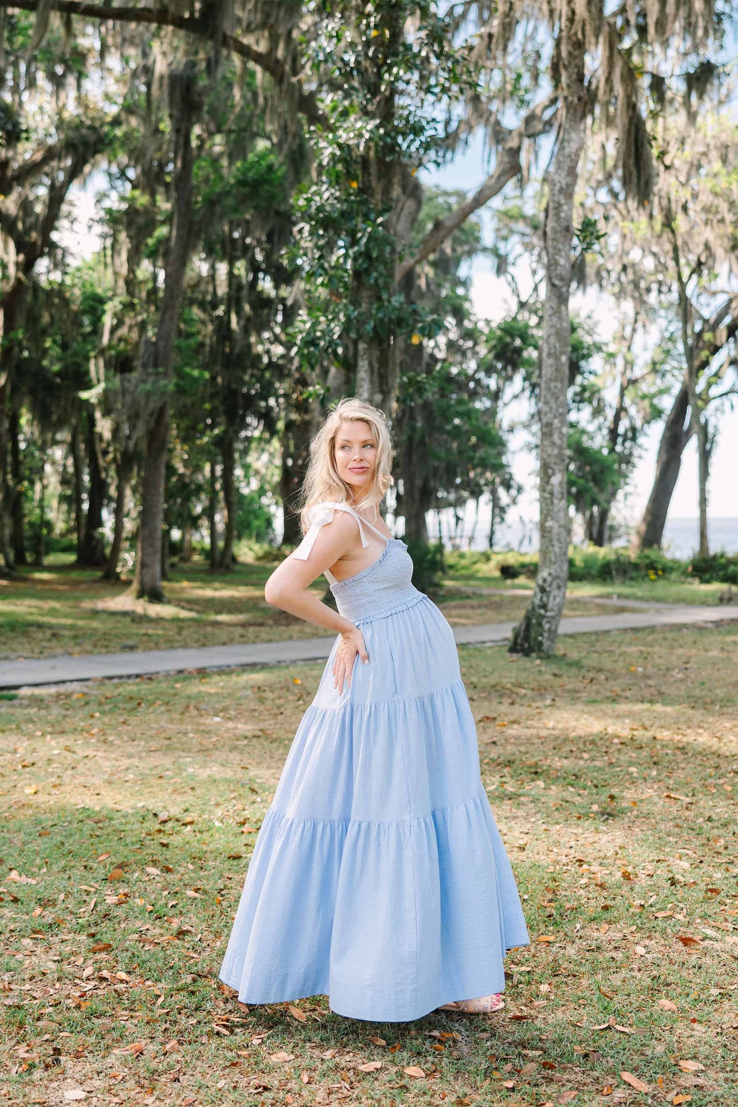 pregnant mom at the park for maternity photos with her cute belly, walking and looking back