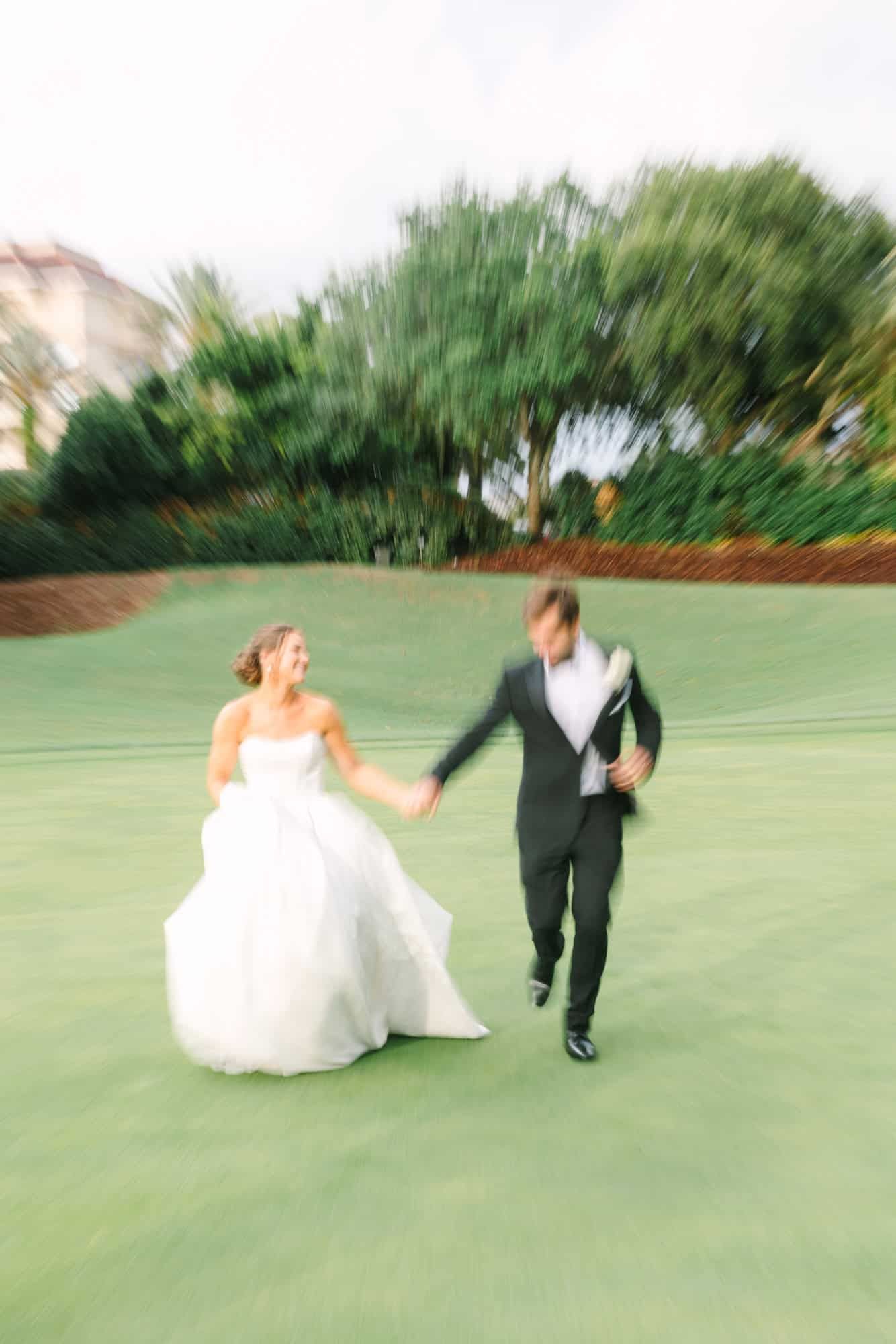 bride and groom running on the golf course with motion blur