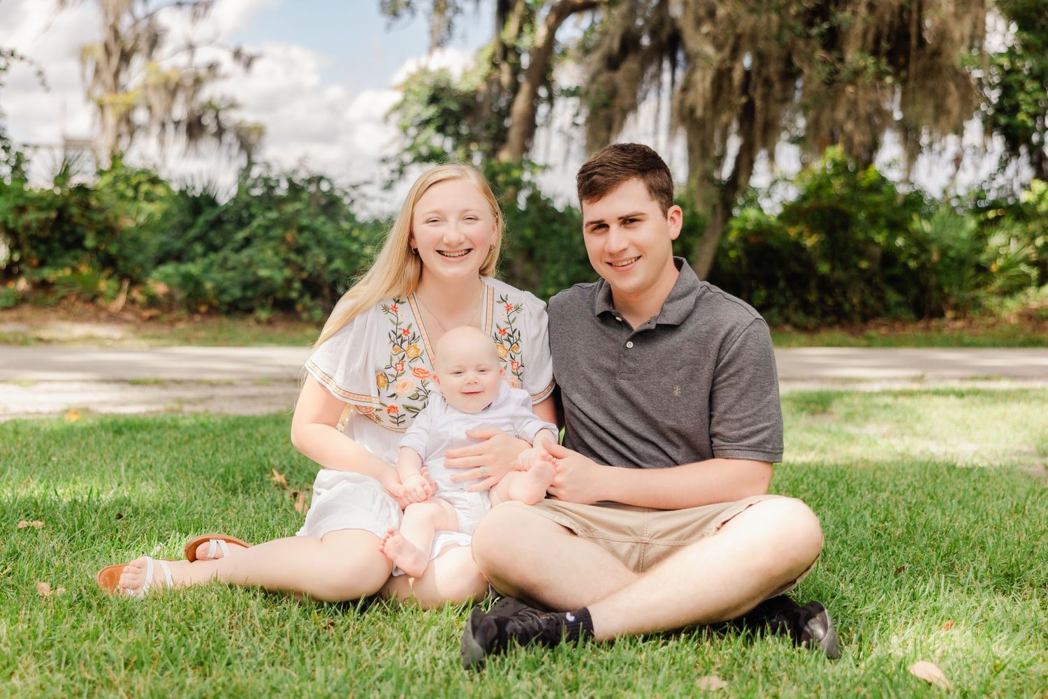 family sitting on the grass smiling