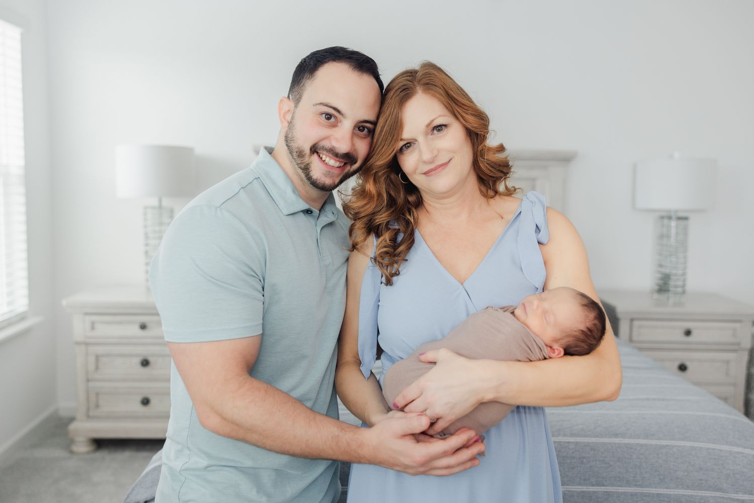 mom and dad smiling for Jacksonville fl photographer holding newborn baby