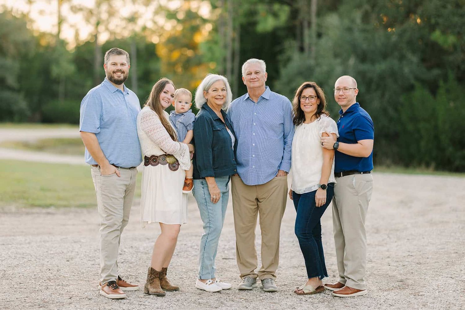 extended family at sunset with trees behind. one grandson is here