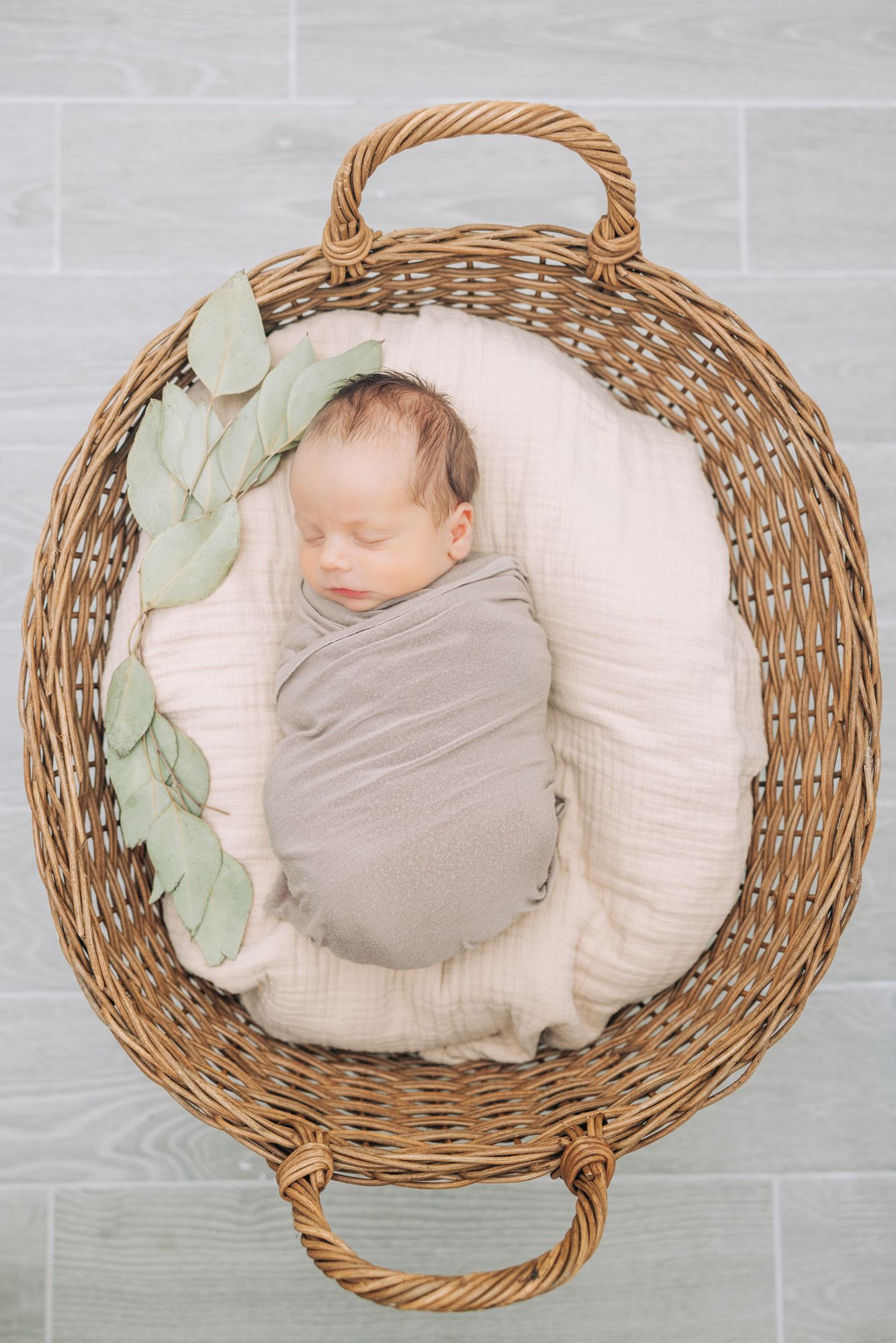 newborn baby swaddled in a basket