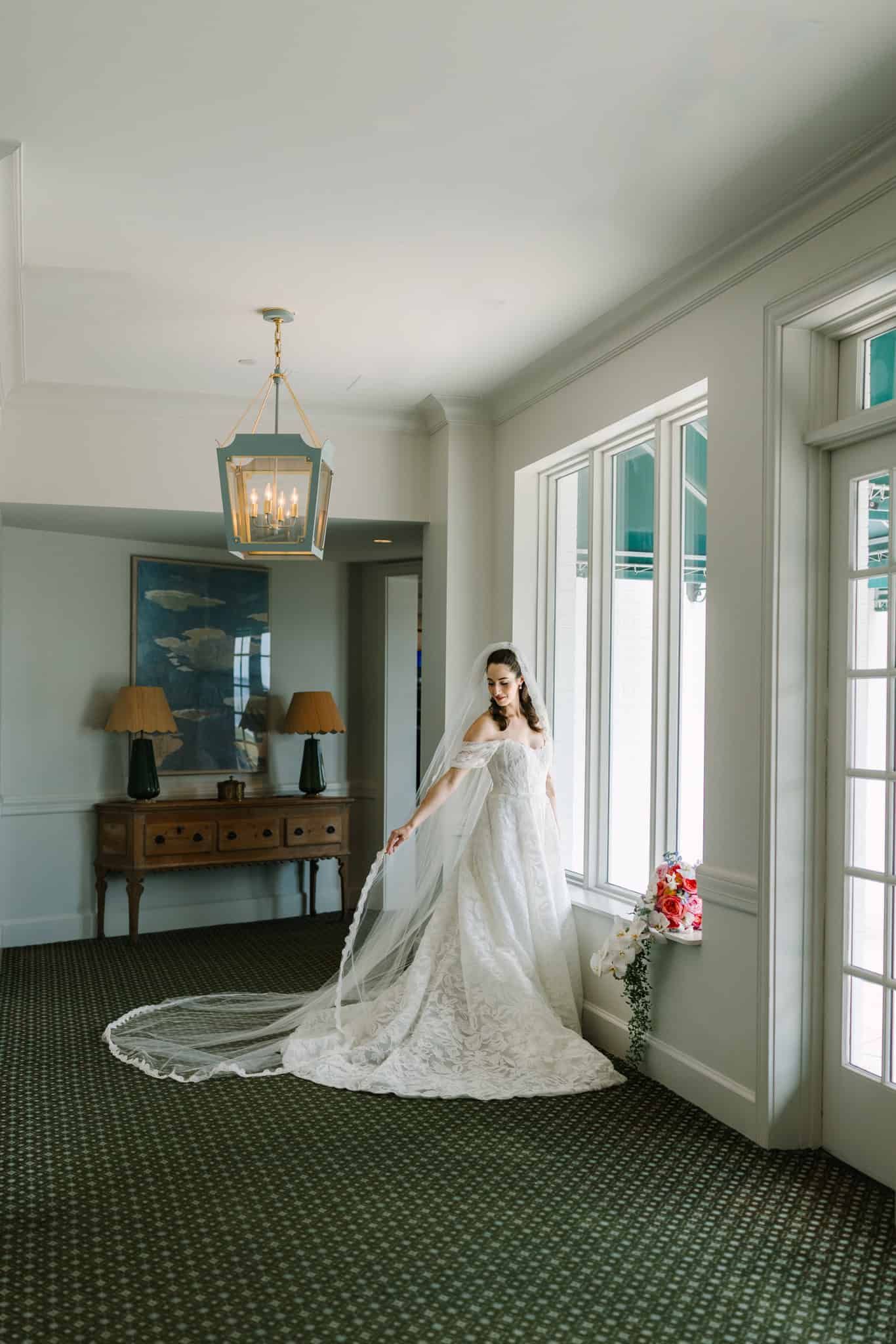 bride fixing her veil in pretty hallway at timuquana country club