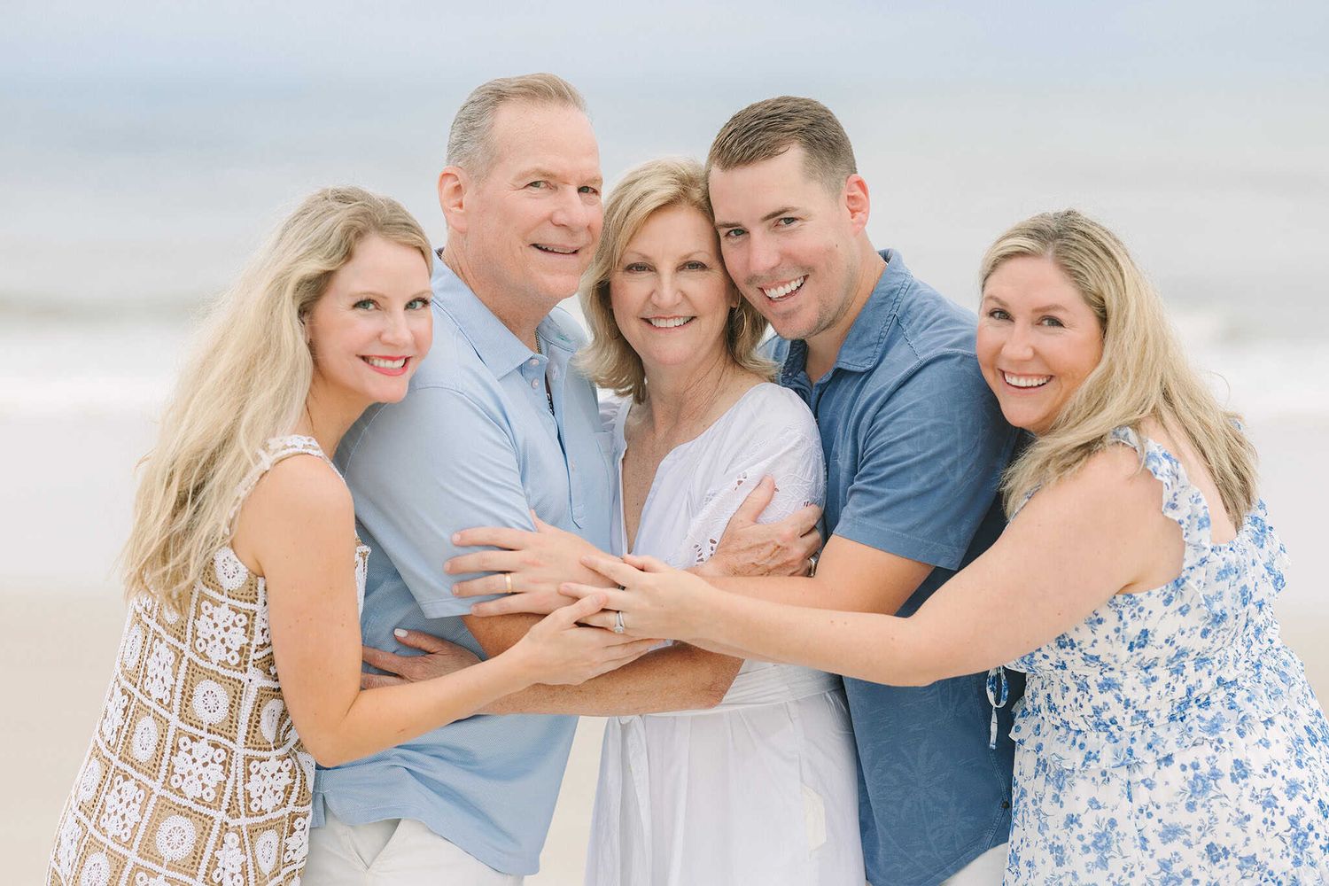 adult children and parents giving a big group hug on Jacksonville Beach fl
