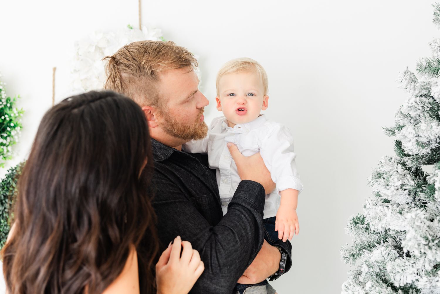little boy making cute face with parents holding him at Christmas mini session in Jacksonville fl