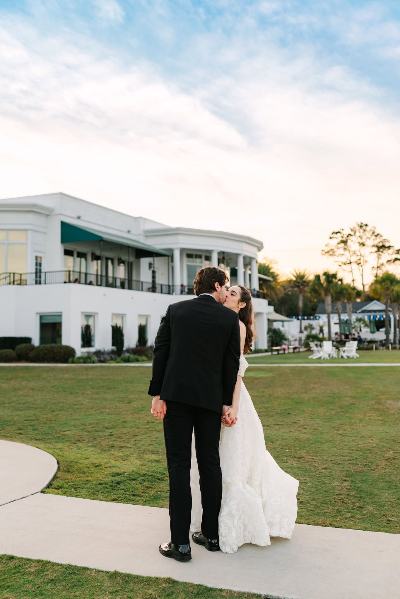 bride and groom kissing outside as sun sets behind venue timuquana country club