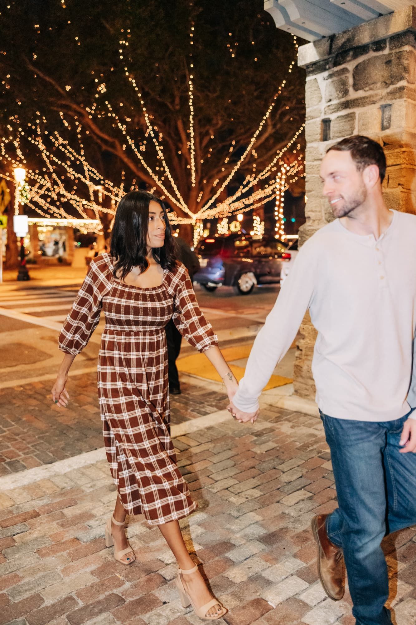 man leading finance walking through night of lights in st Augustine engagement