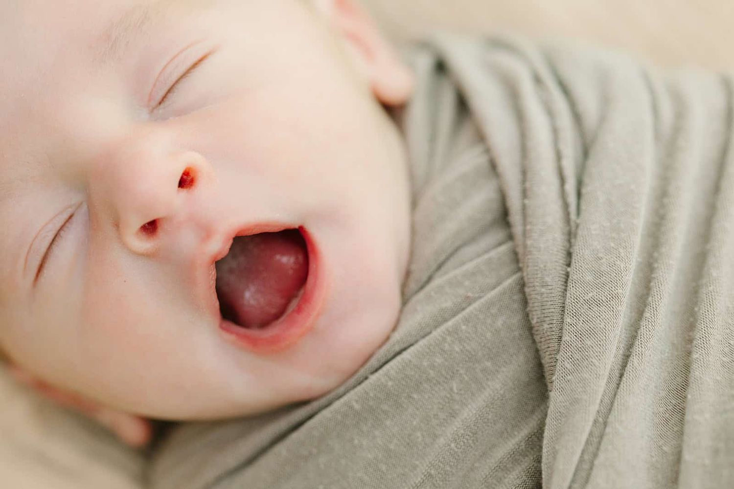 close up of newborn baby yawning