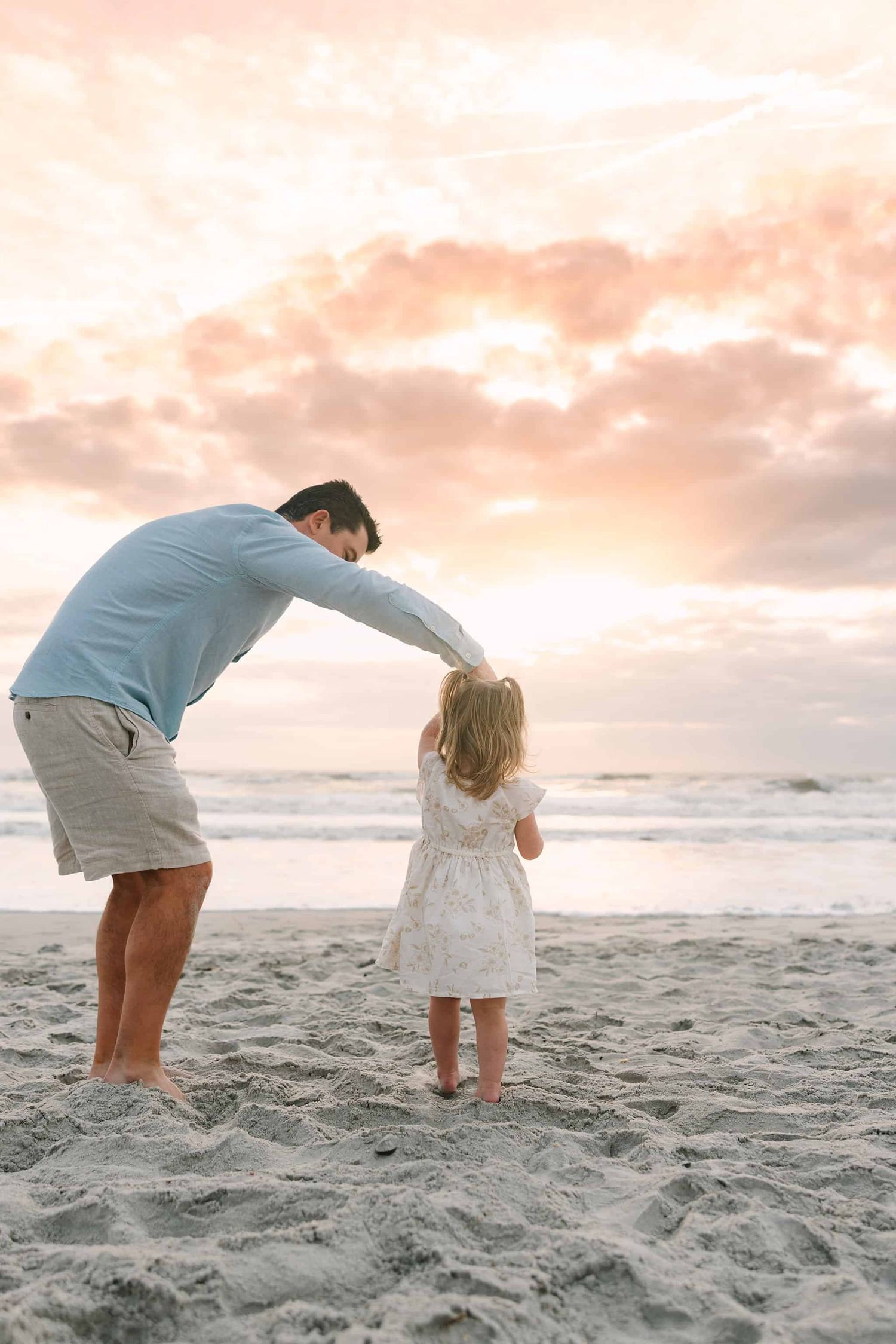 dad twirling daughter in the sunrise at Jacksonville Beach