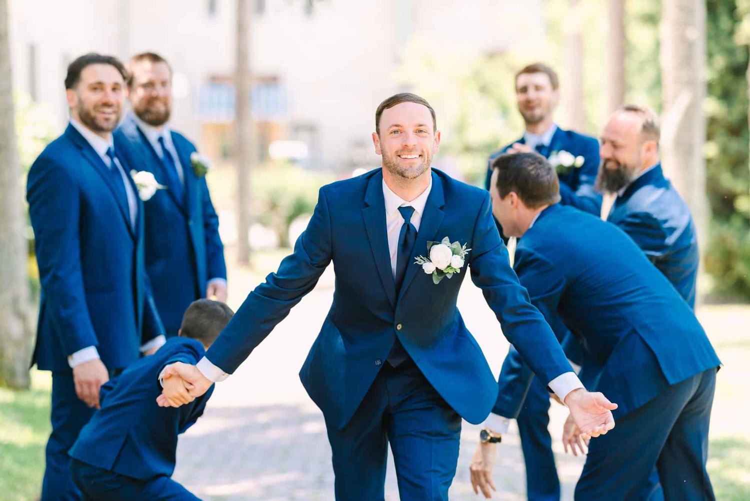 groom high fiving his groomsmen