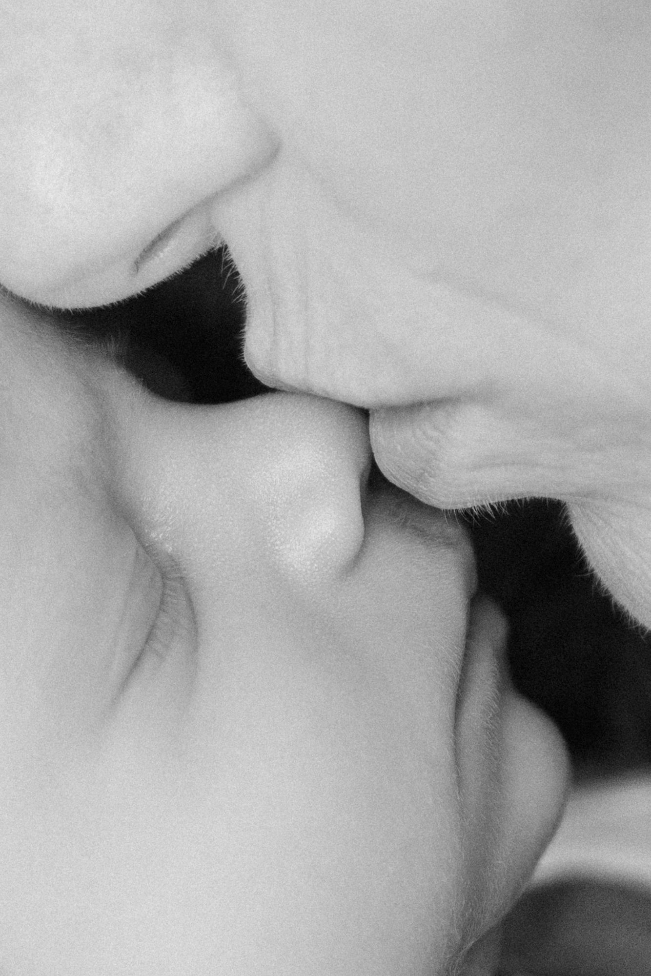 close up of mom kissing newborn baby nose