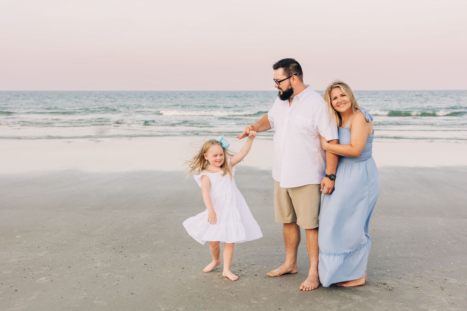 happy family on Jacksonville beach with father twirling daughter