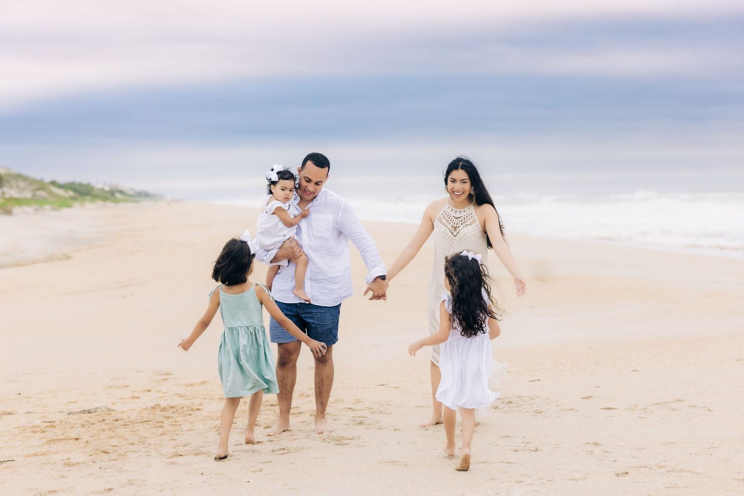 daughters running towards parents who are waiting to hug them