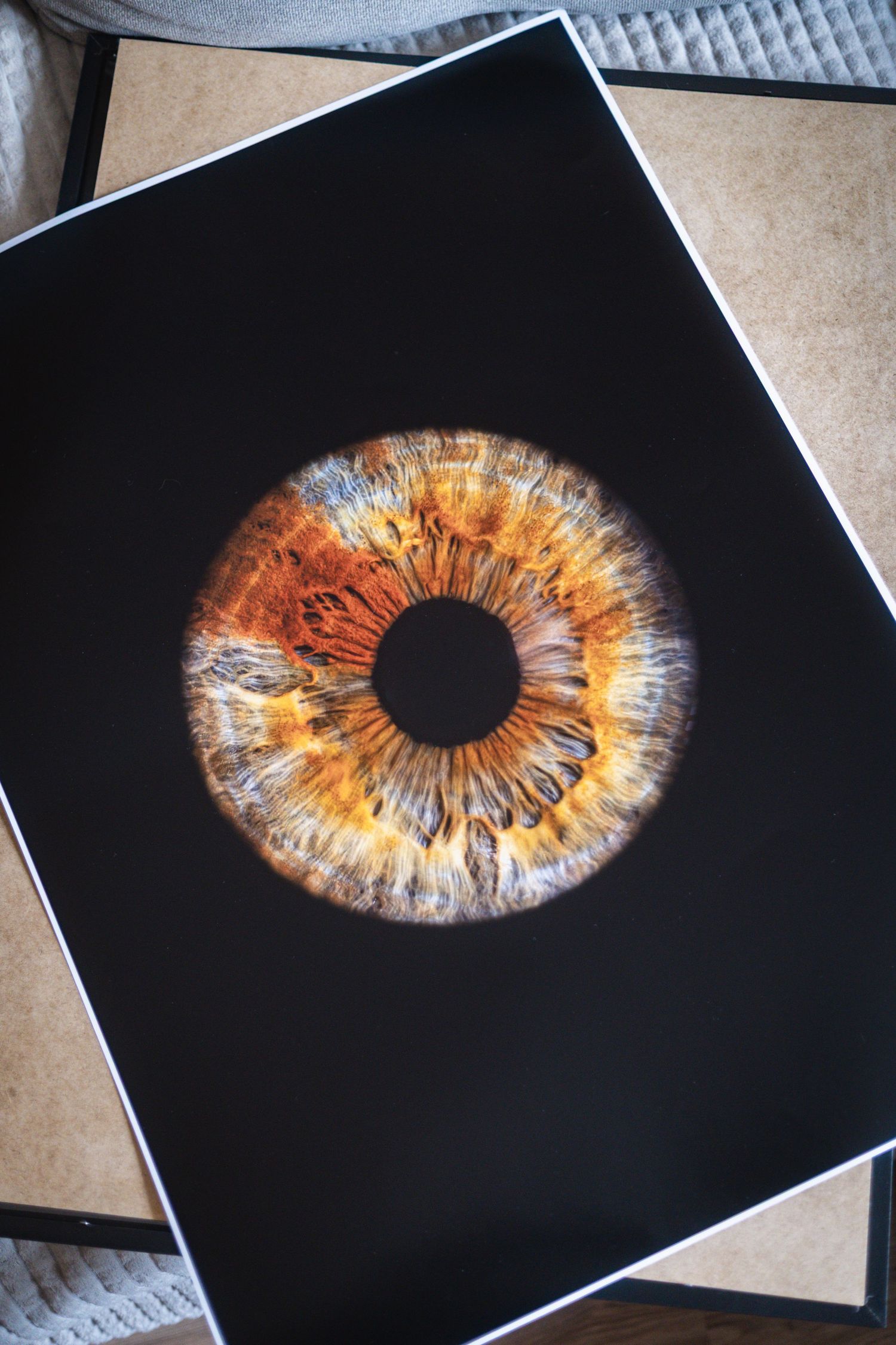 A series of four artistic photographs showing close-up macro shots of human irises with golden and amber tones on black backgrounds.