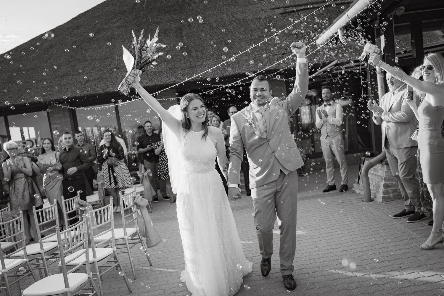 Wedding guests create a sparkler exit tunnel for the newlyweds in black and white photography.